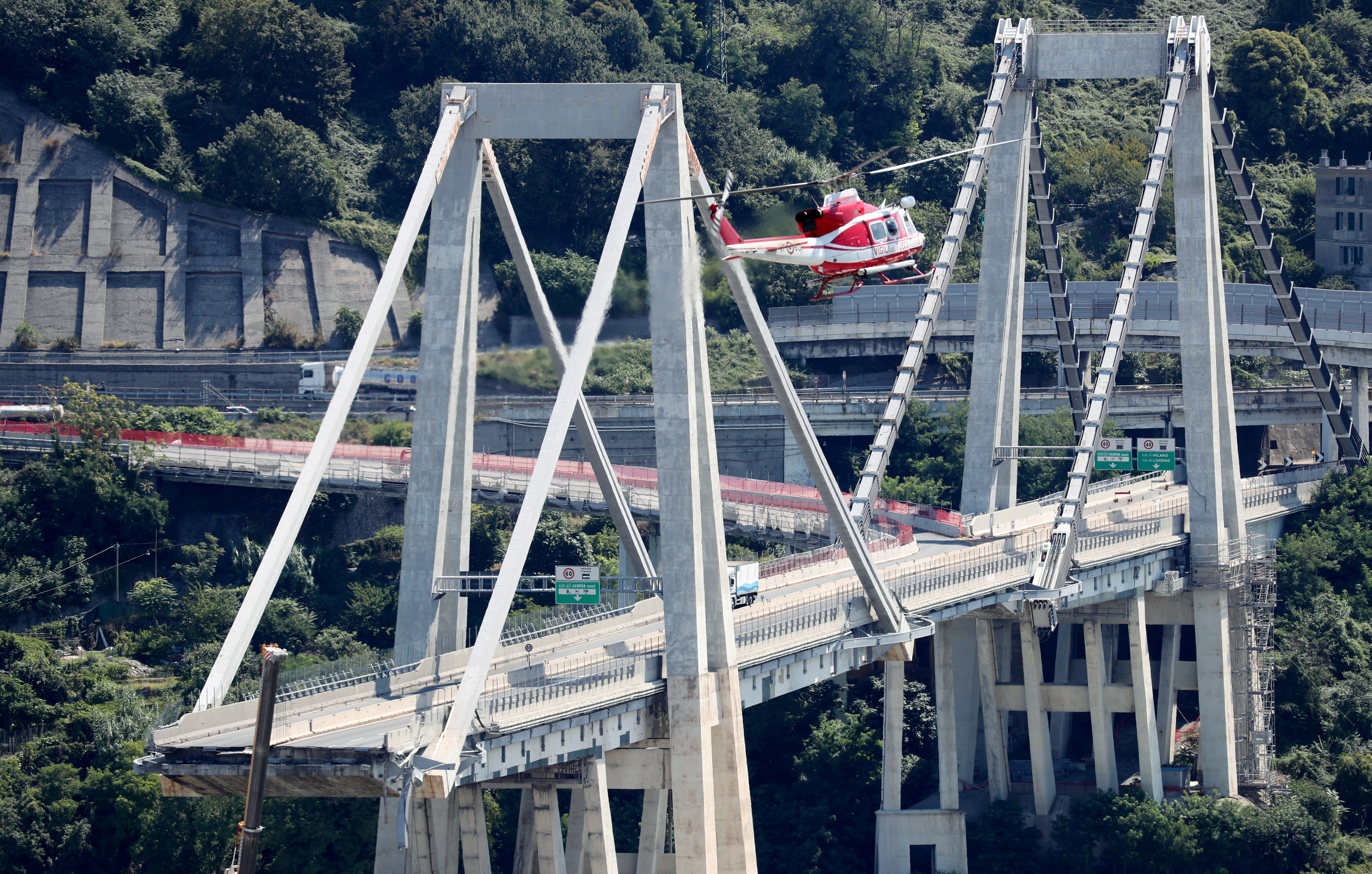 Firefighter helicopter flies over the collapsed Morandi Bridge in the port city of Genoa