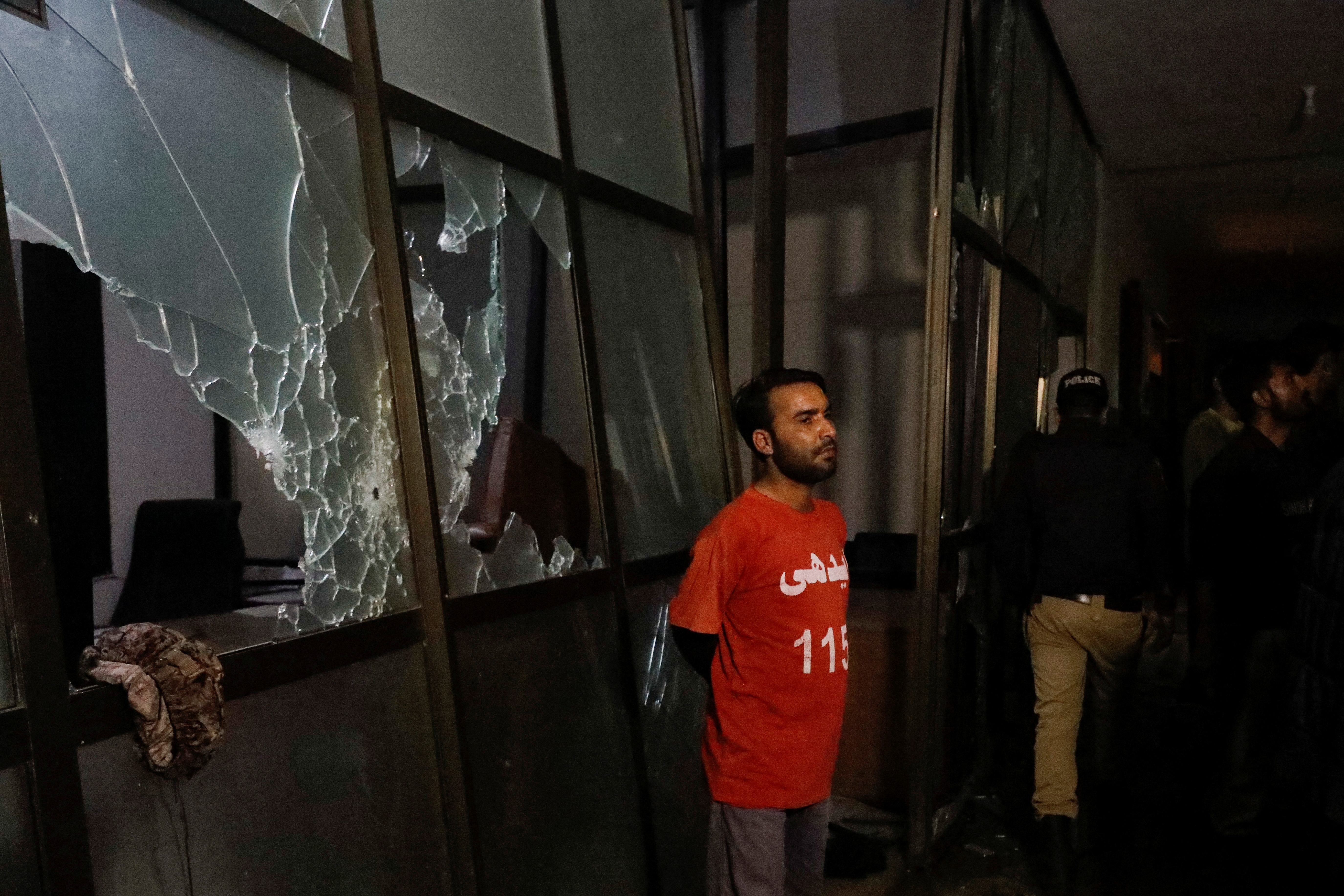 A rescue worker stands in the aftermath of an attack on a police station in Karachi