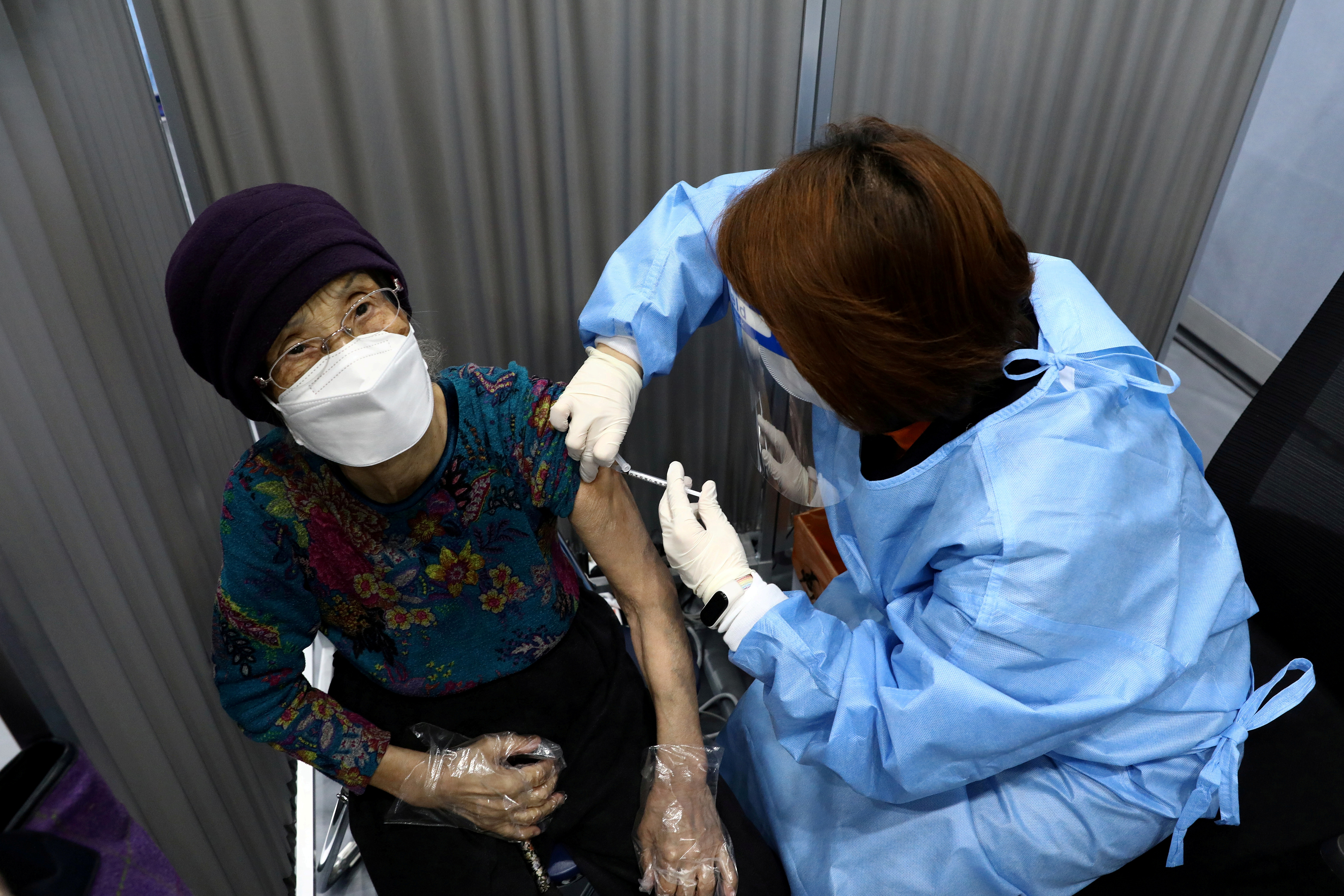 A South Korean woman receives her first dose of the Pfizer-BioNTech coronavirus disease (COVID-19) vaccine at a vaccination centre in Seoull