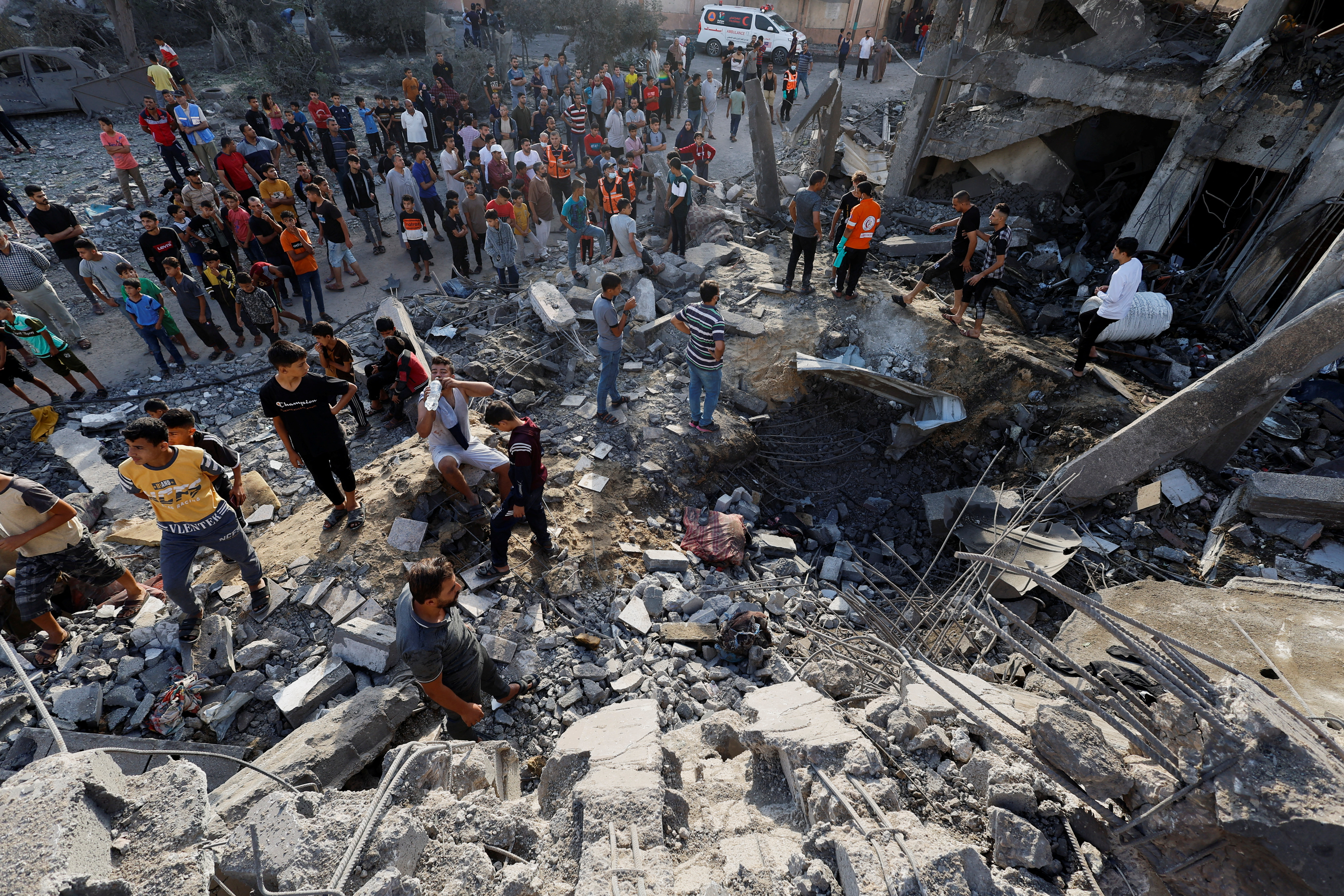 Palestinians search for casualties under the rubble of a building destroyed by Israeli strikes in Khan Younis