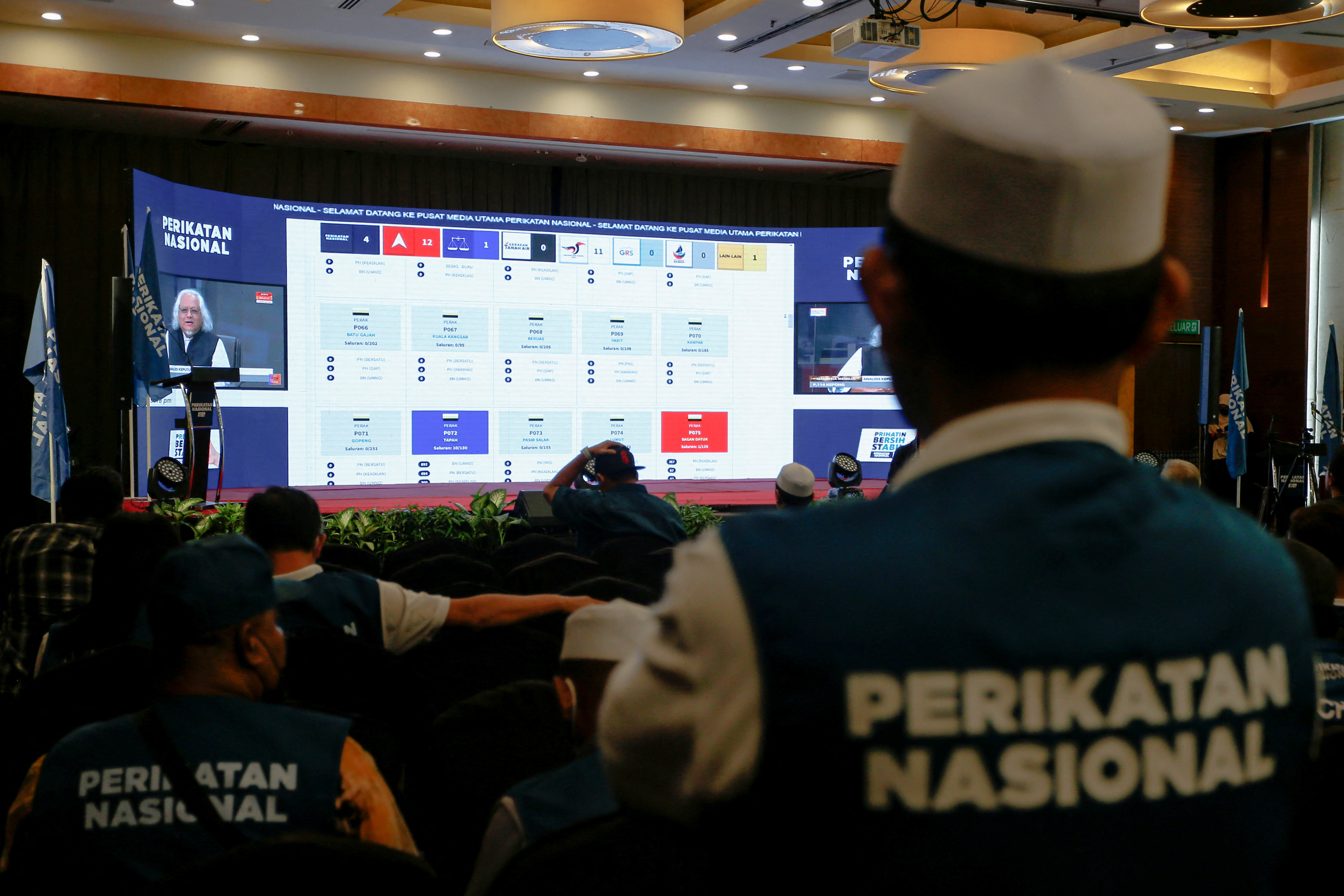 Supporters of Perikatan Nasional watch a video stream for live results of Malaysia's 15th general election at a hotel in Shah Alam