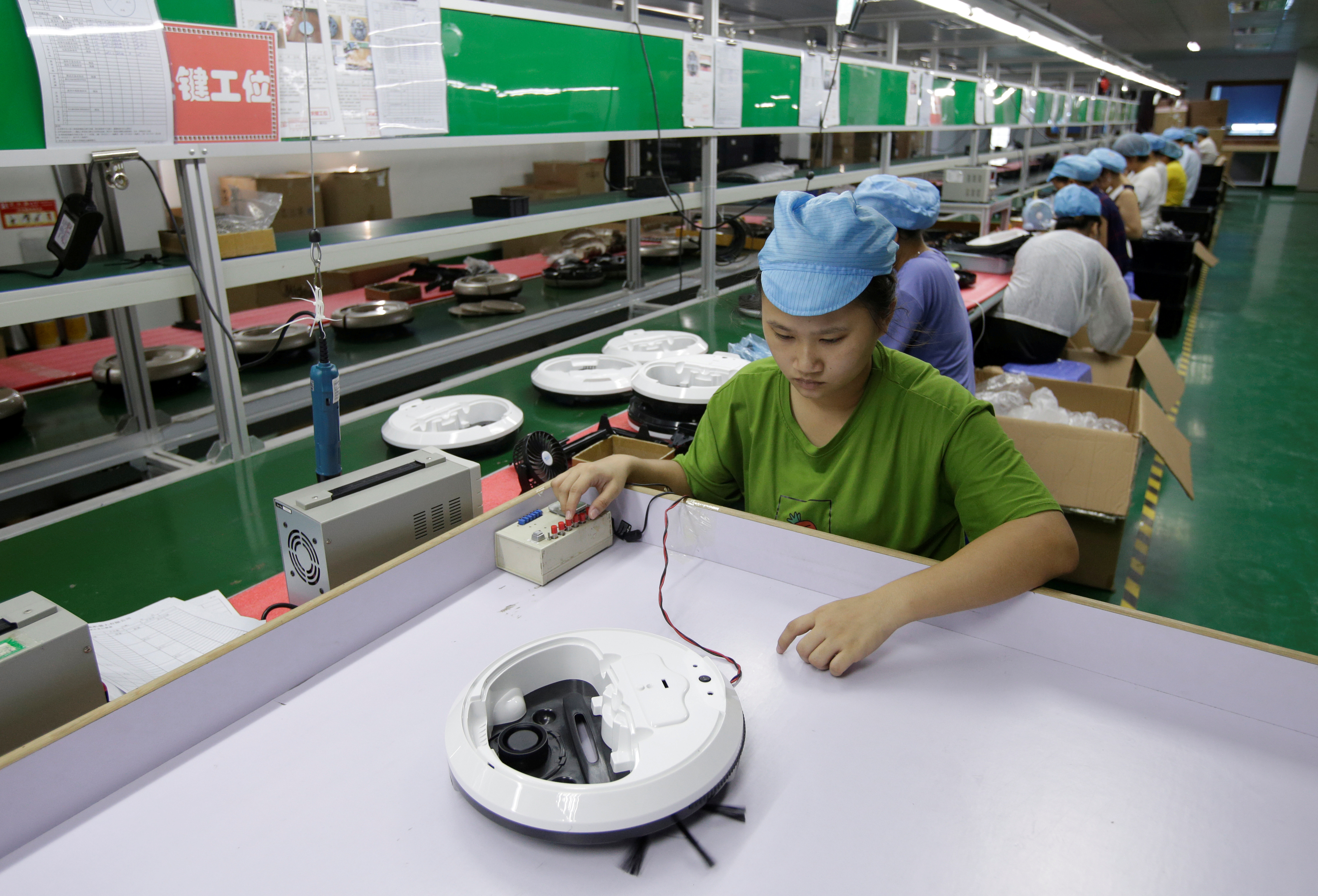 An employee works on the production line of a robot vacuum cleaner at a factory of Matsutek in Shenzhen