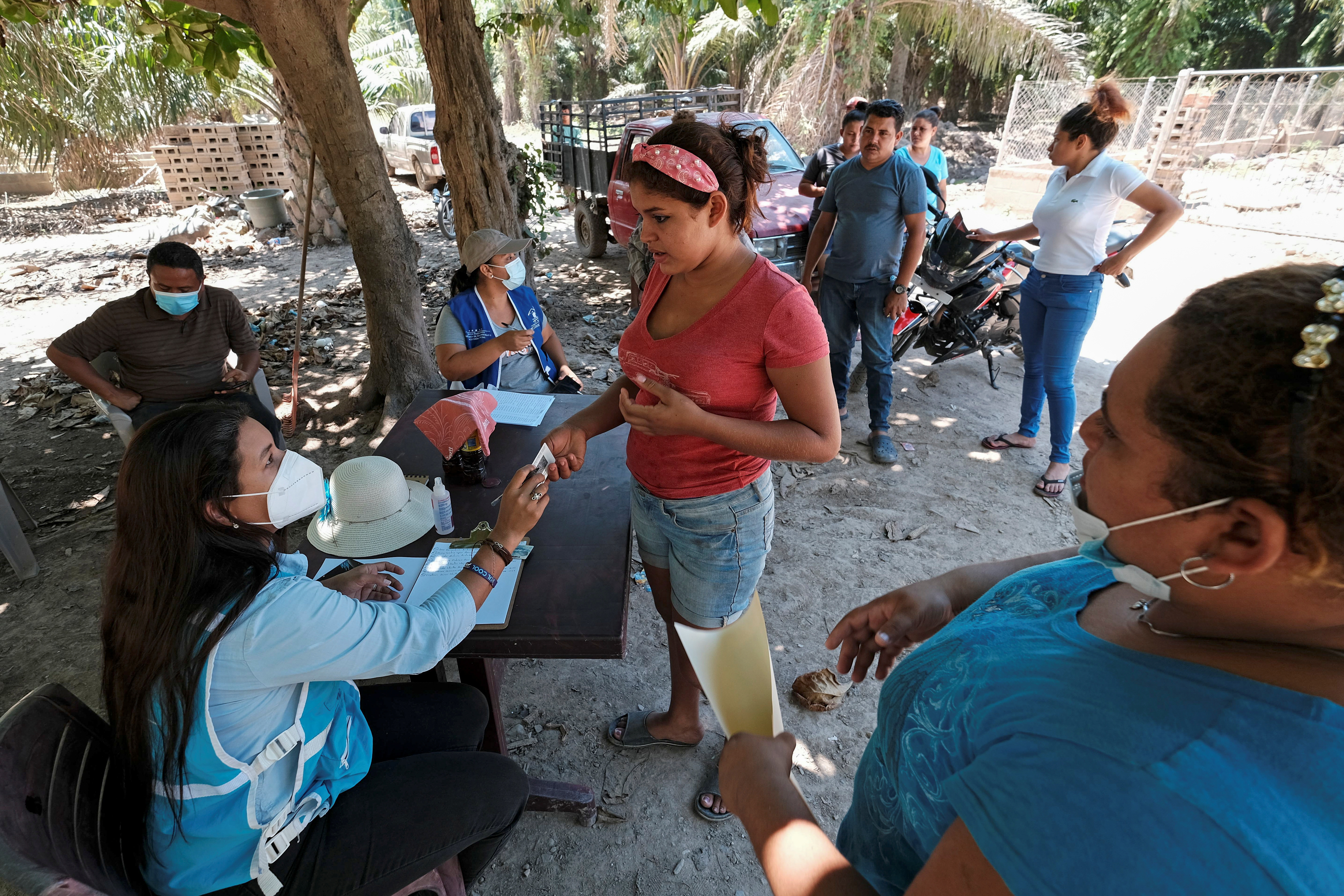 An activist from the ruling Partido Nacional (National Party) holds the identification of a woman to register on a list to receive help from the government foe the people affected by the floods caused by hurricanes Eta and Iota, in El Progreso, Honduras March 27, 2021. REUTERS/Yoseph Amaya 