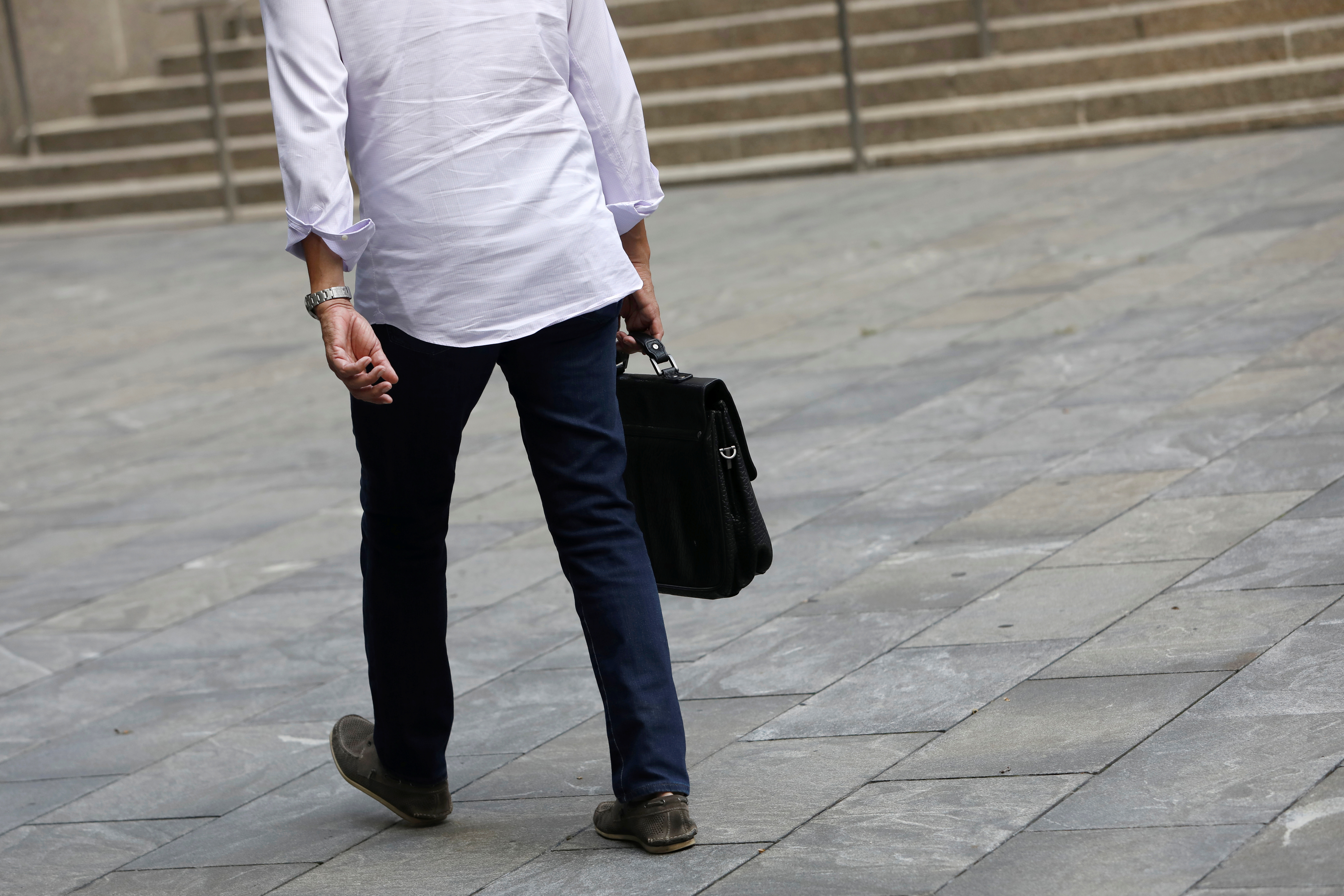 A man walks through the street carrying a briefcase in Manhattan, New York City