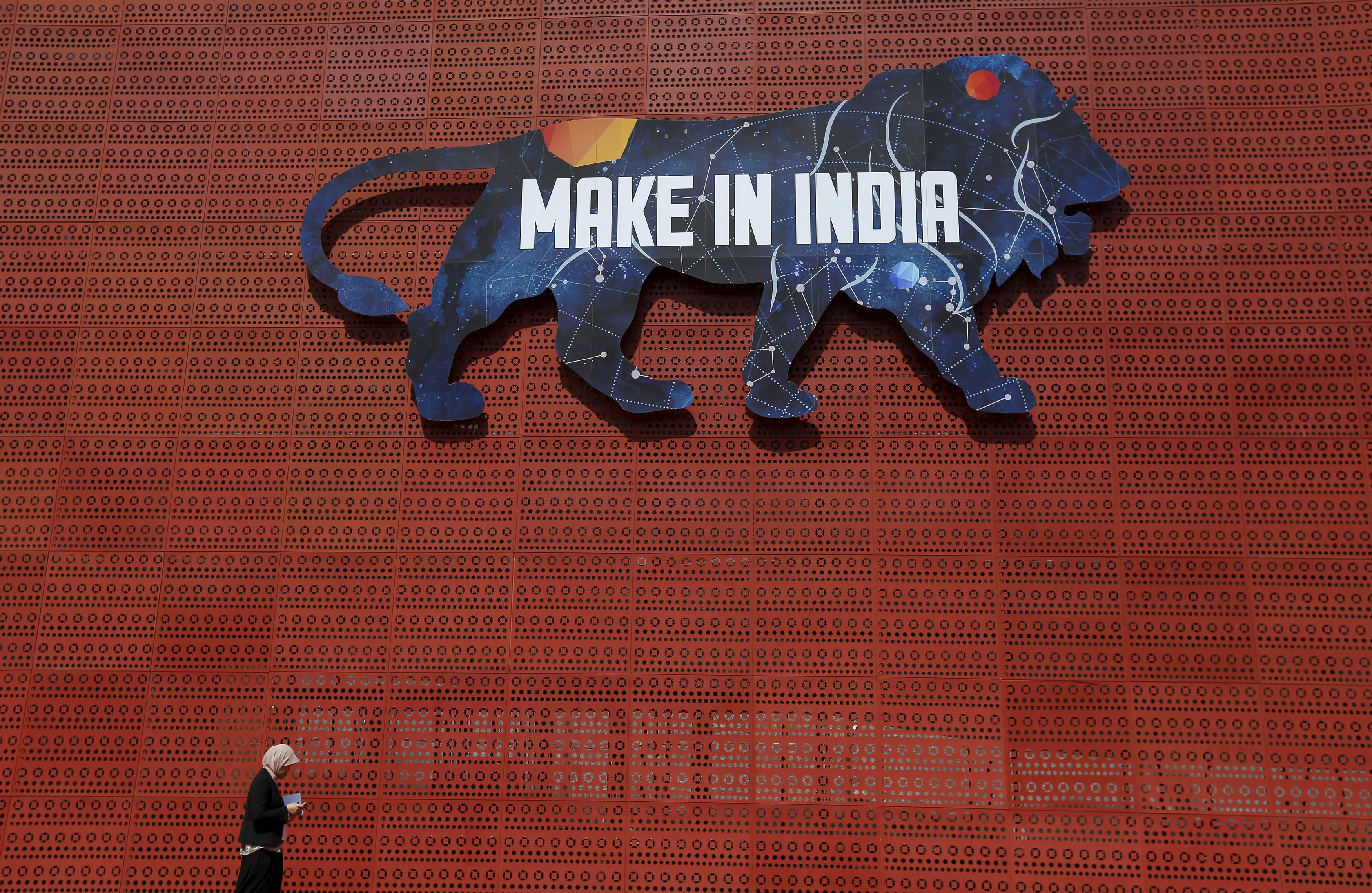 A participant walks past a pavilion at the exhibition centre of the 'Make In India' week in Mumbai