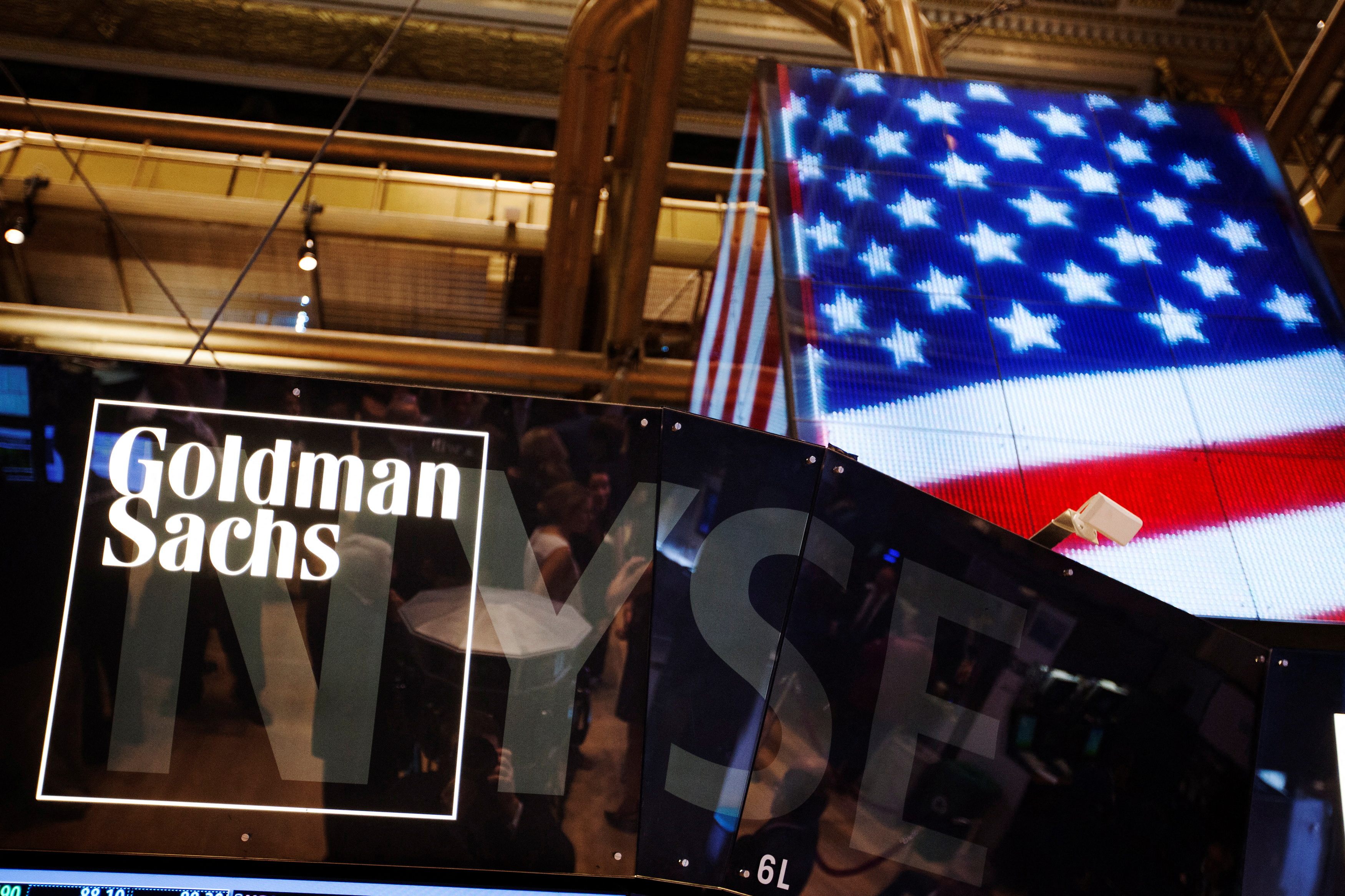 The Goldman Sachs logo is displayed on a post above the floor of the New York Stock Exchange