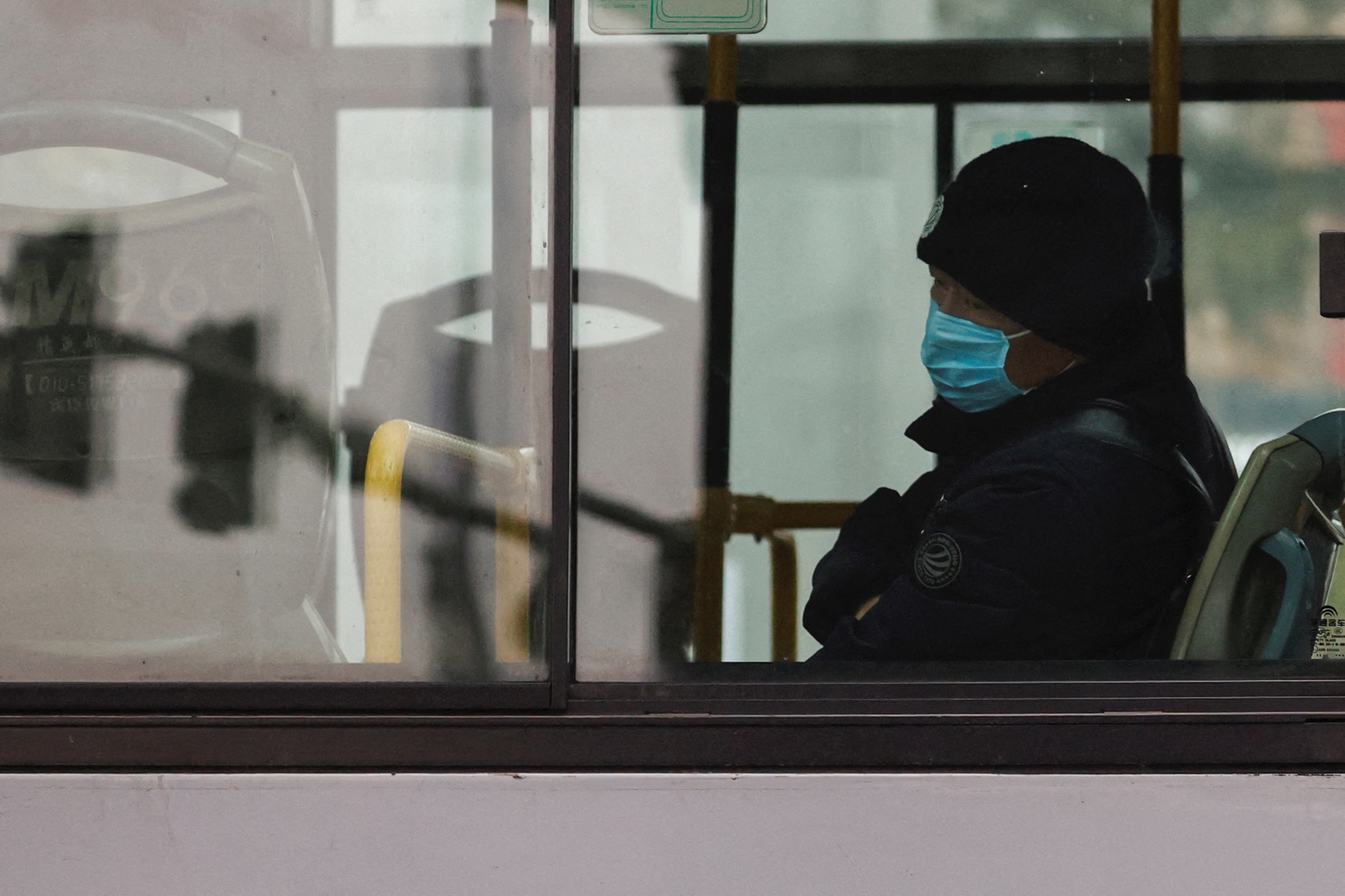 A man wearing a face mask sits in a bus, amidst coronavirus disease (COVID-19) pandemic, in Beijing