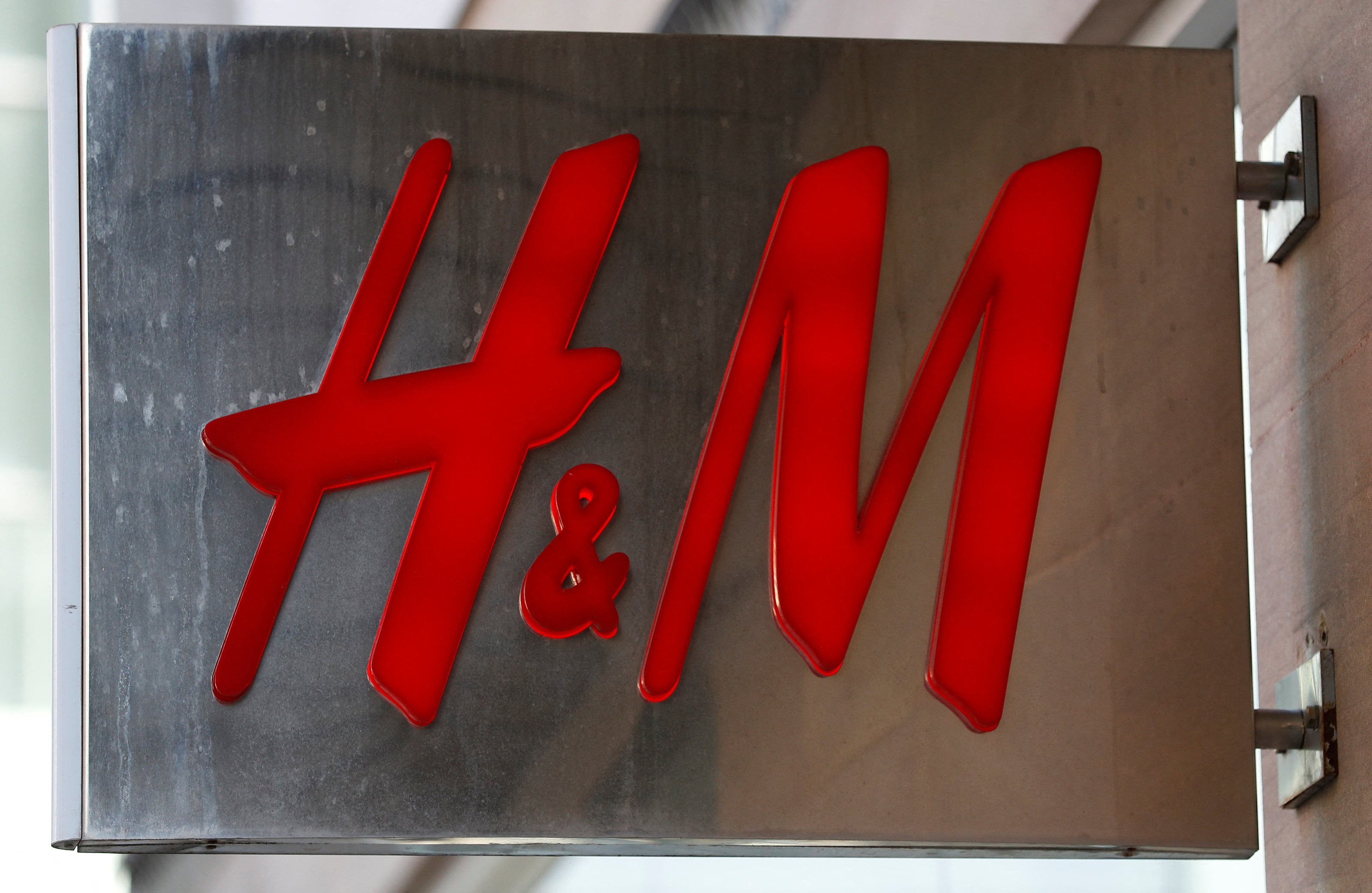 A company logo is pictured outside a branch clothing company H&M in Manchester northern England