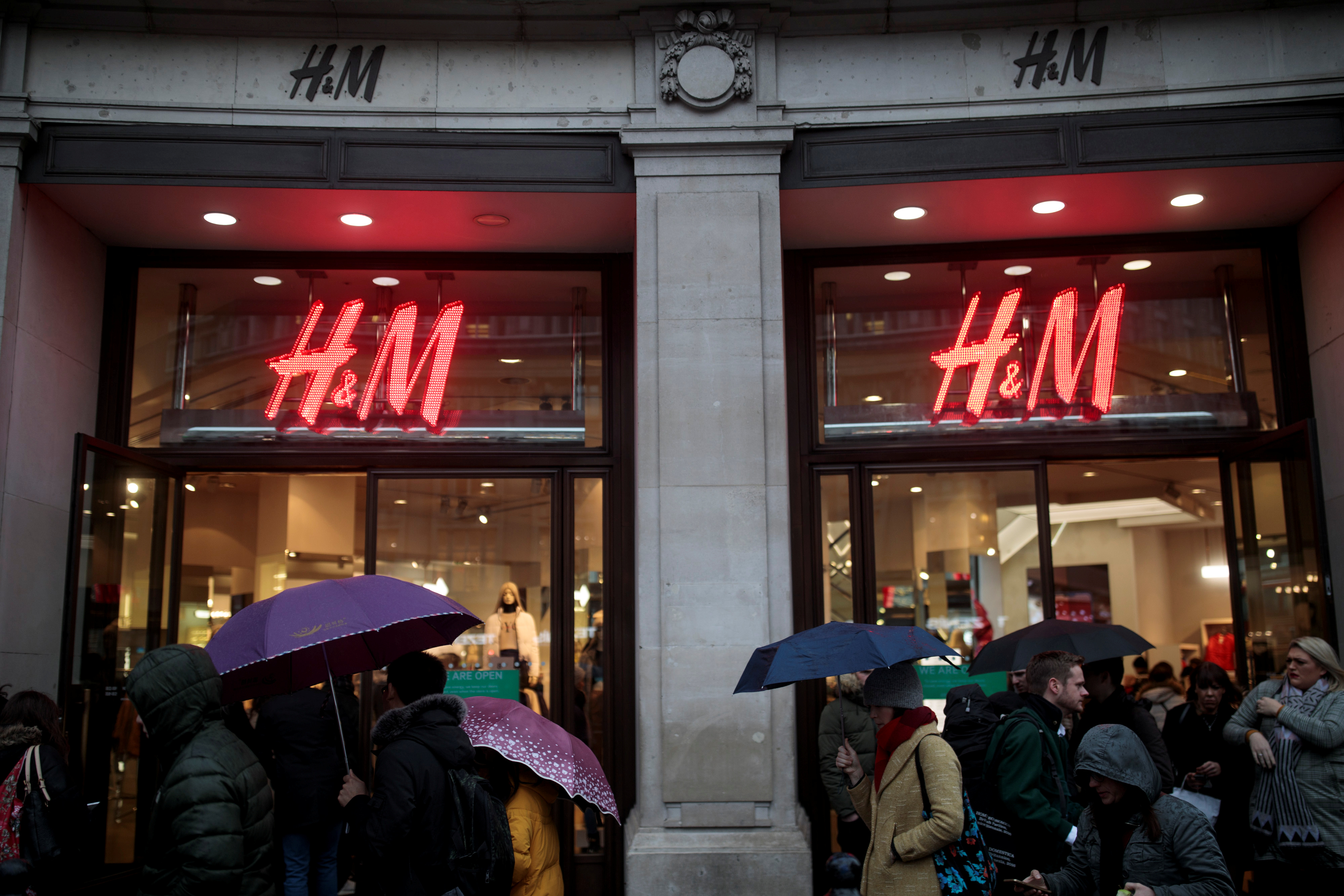 Shoppers walk past an H&M store on Oxford Street in London