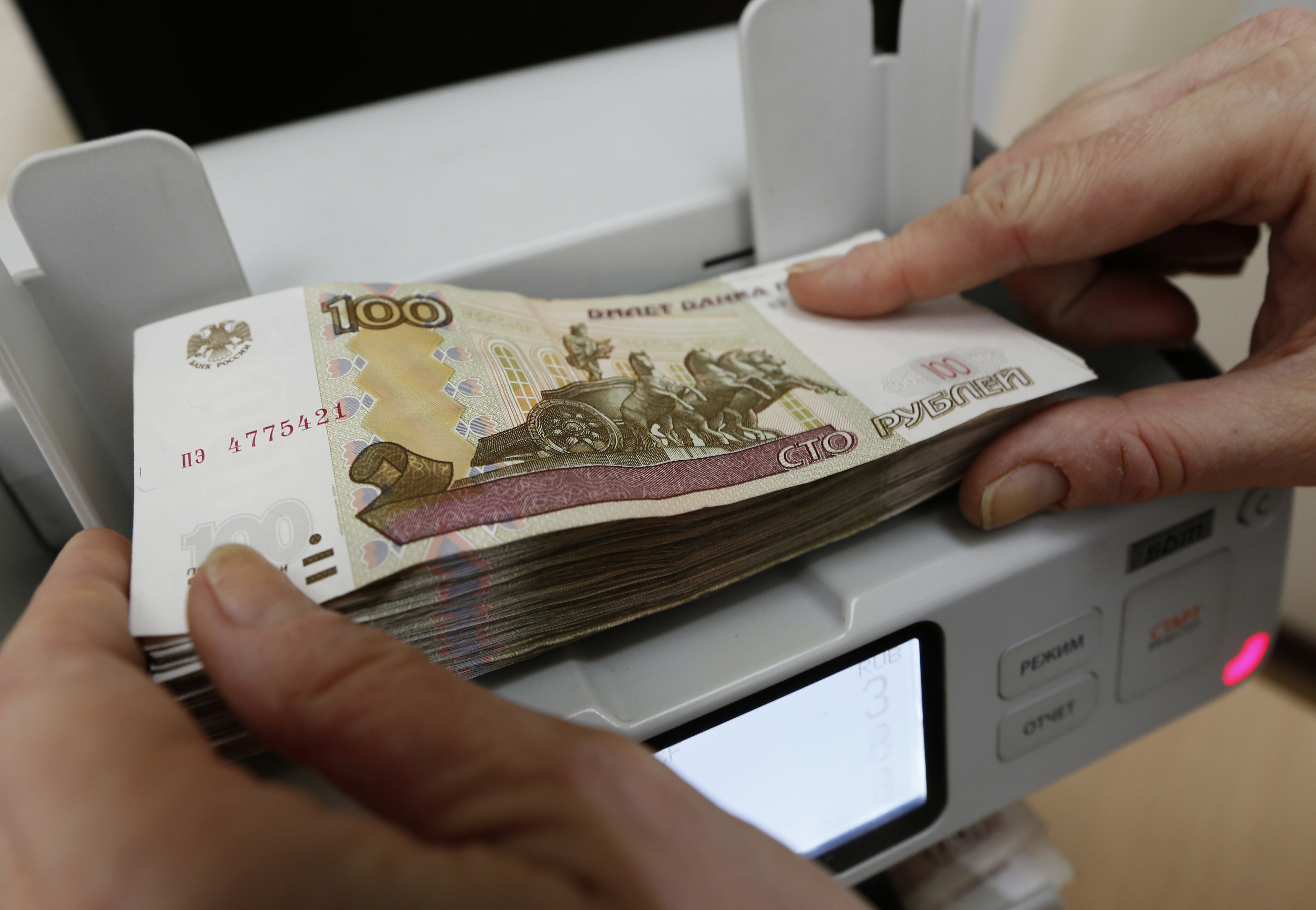 Cashier counts Russian rouble banknotes in Krasnoyarsk