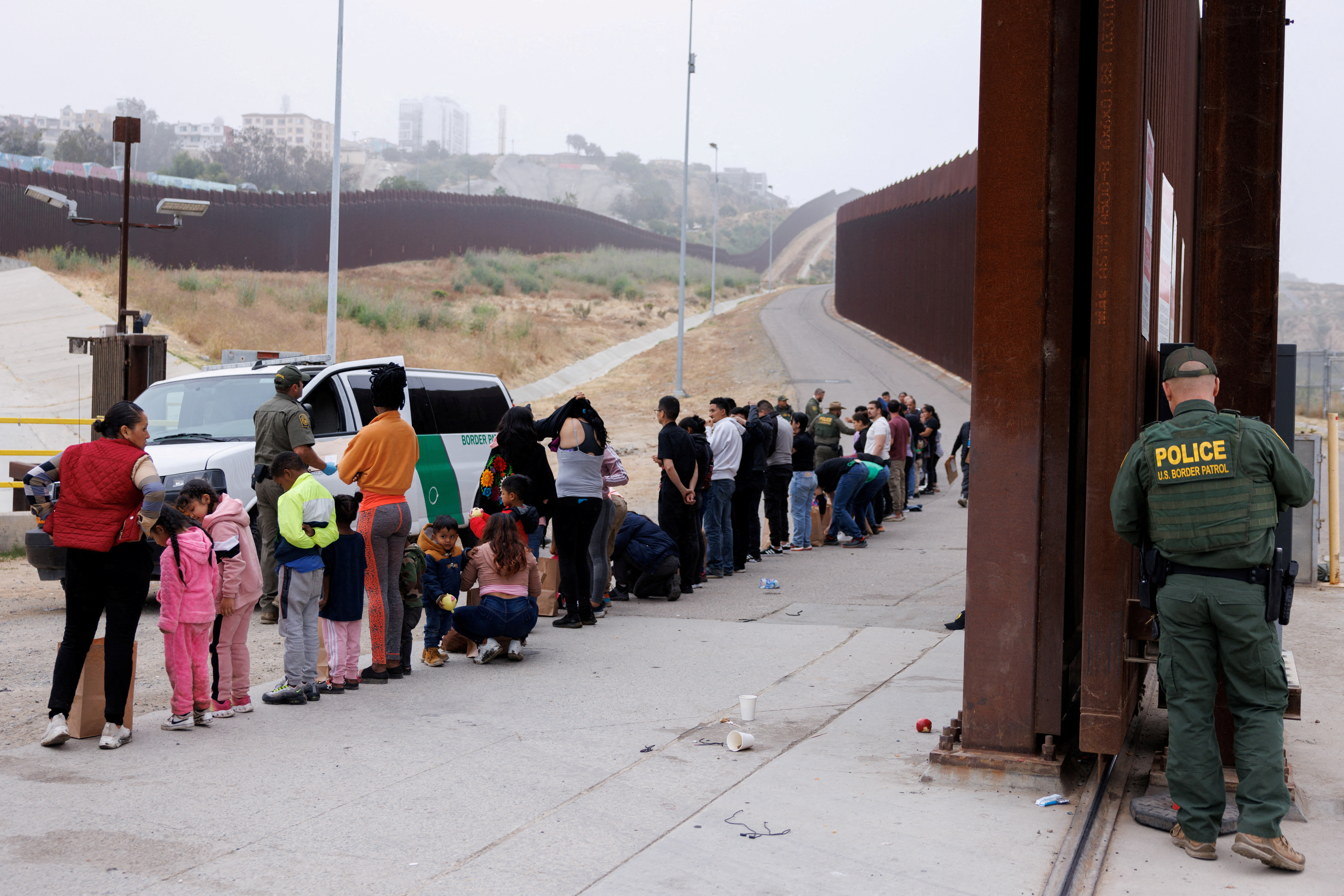 Asylum-seekers at border walls between the U.S. and Mexico