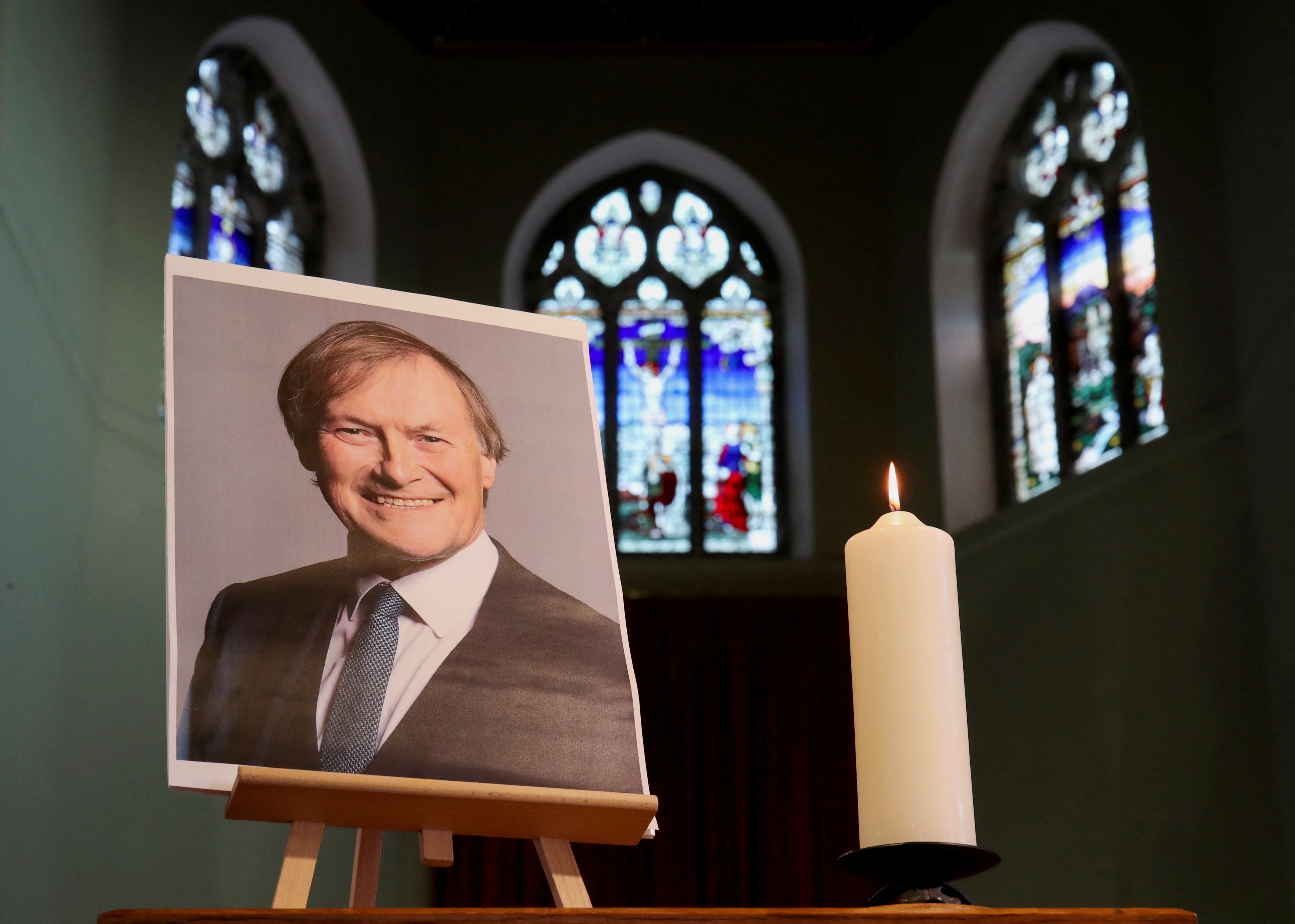 A candle and a portrait of British MP David Amess are seen at the church of St Michael's and all Angels, in Leigh-on-Sea