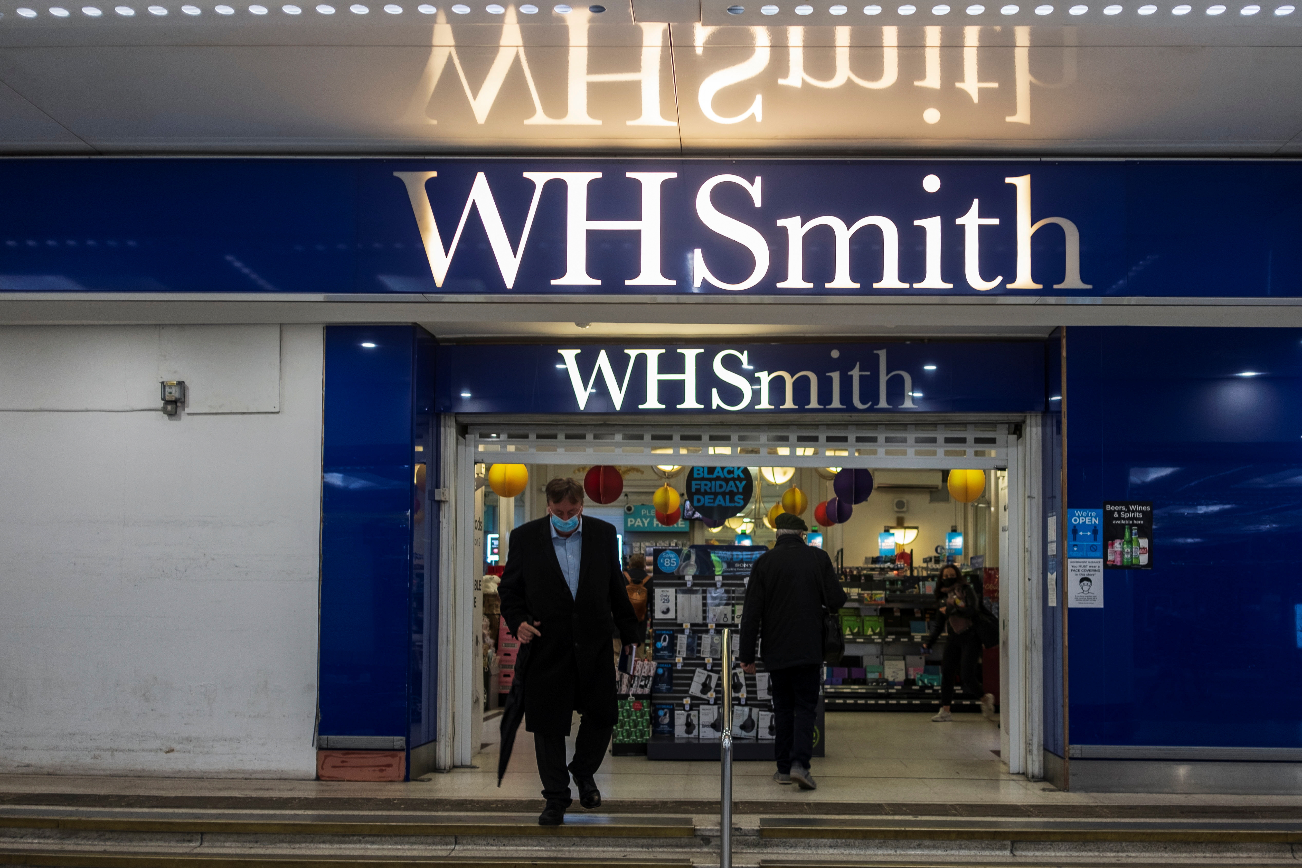 A person wearing a mask leaves a WH Smith store in London