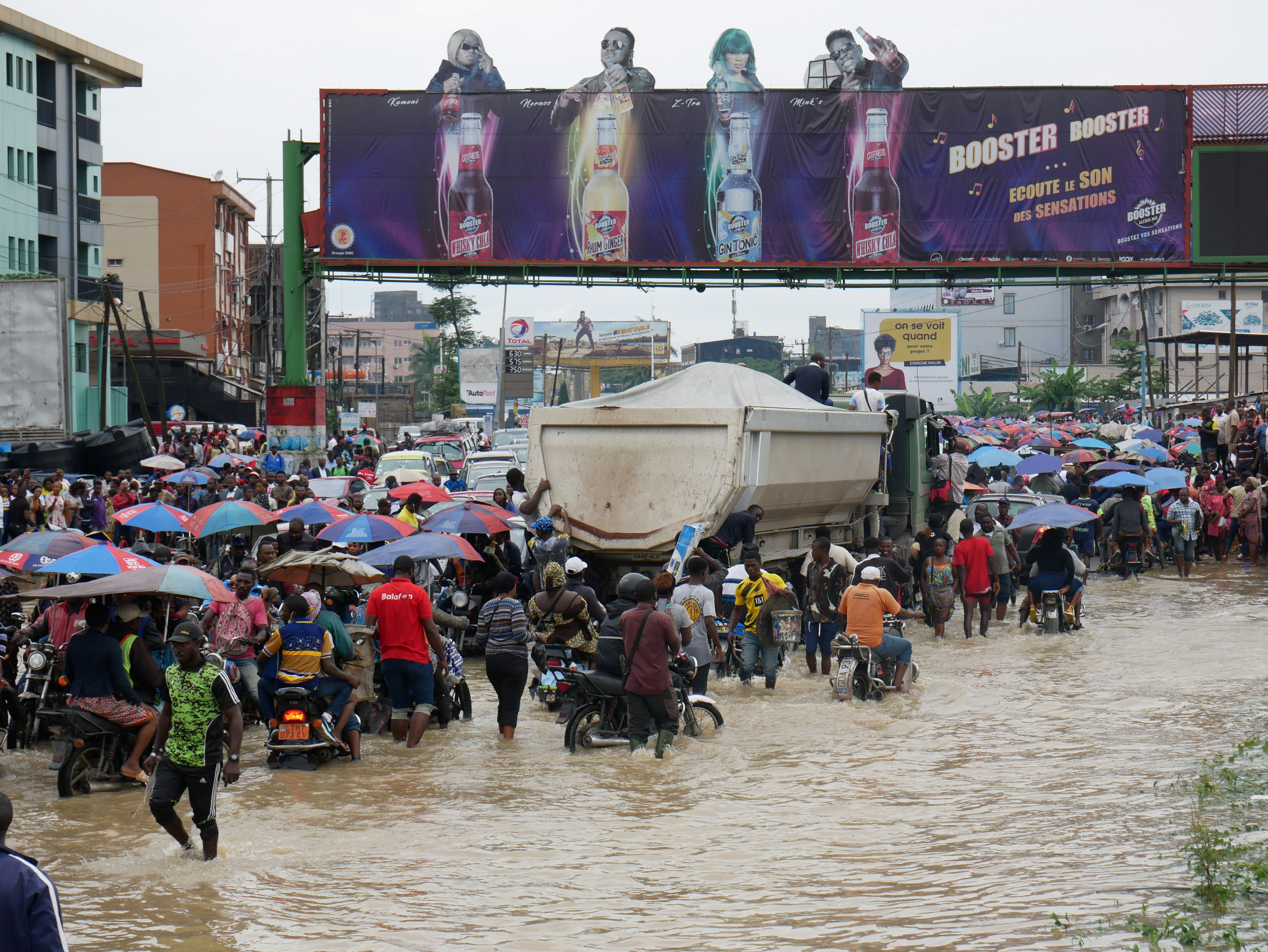 People make their way through a flooded street after the heavy rains in Douala