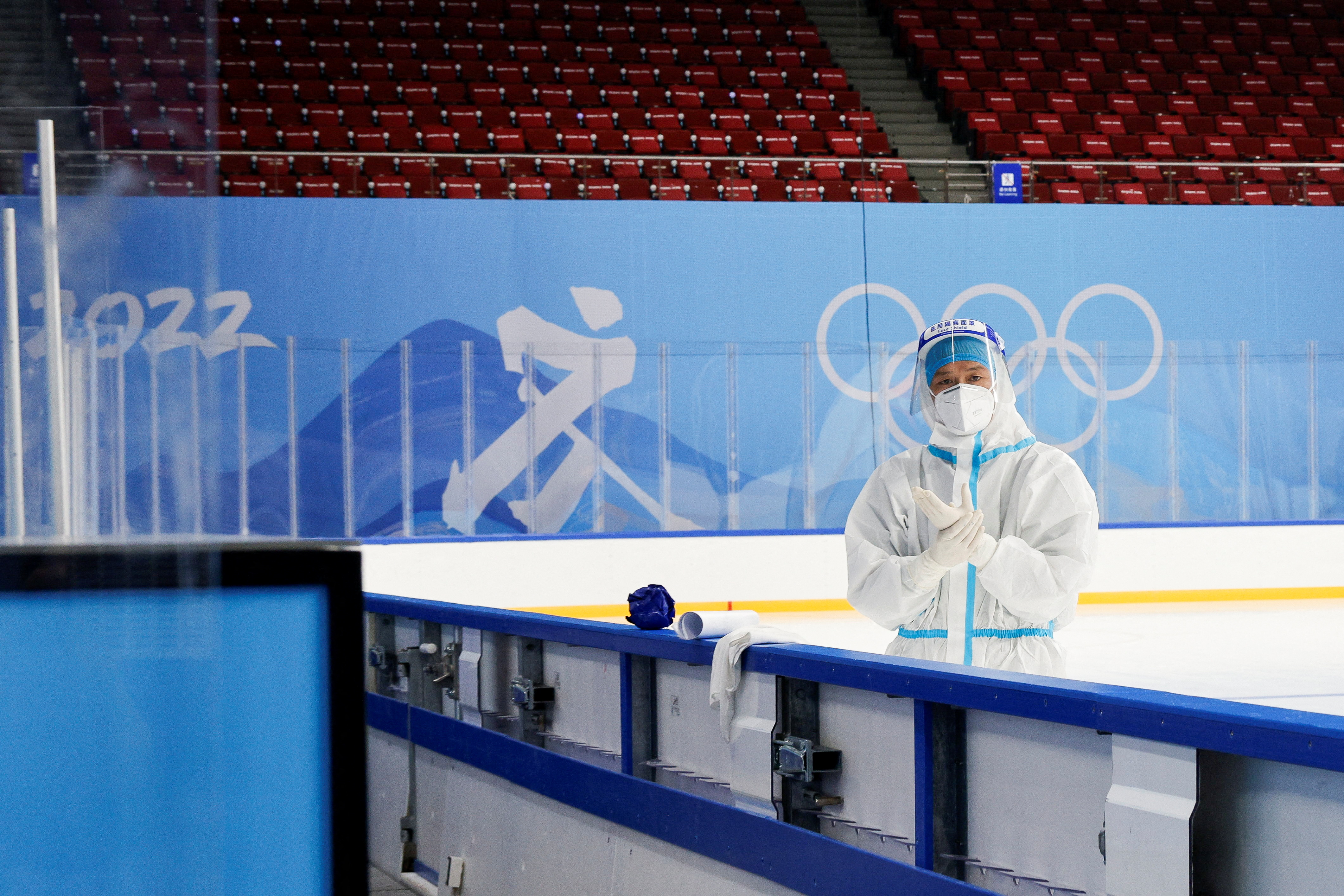 A worker wearing PPE adjusts his gloves at the Wukesong Arena, ahead of the Beijing 2022 Winter Olympics, in Beijing