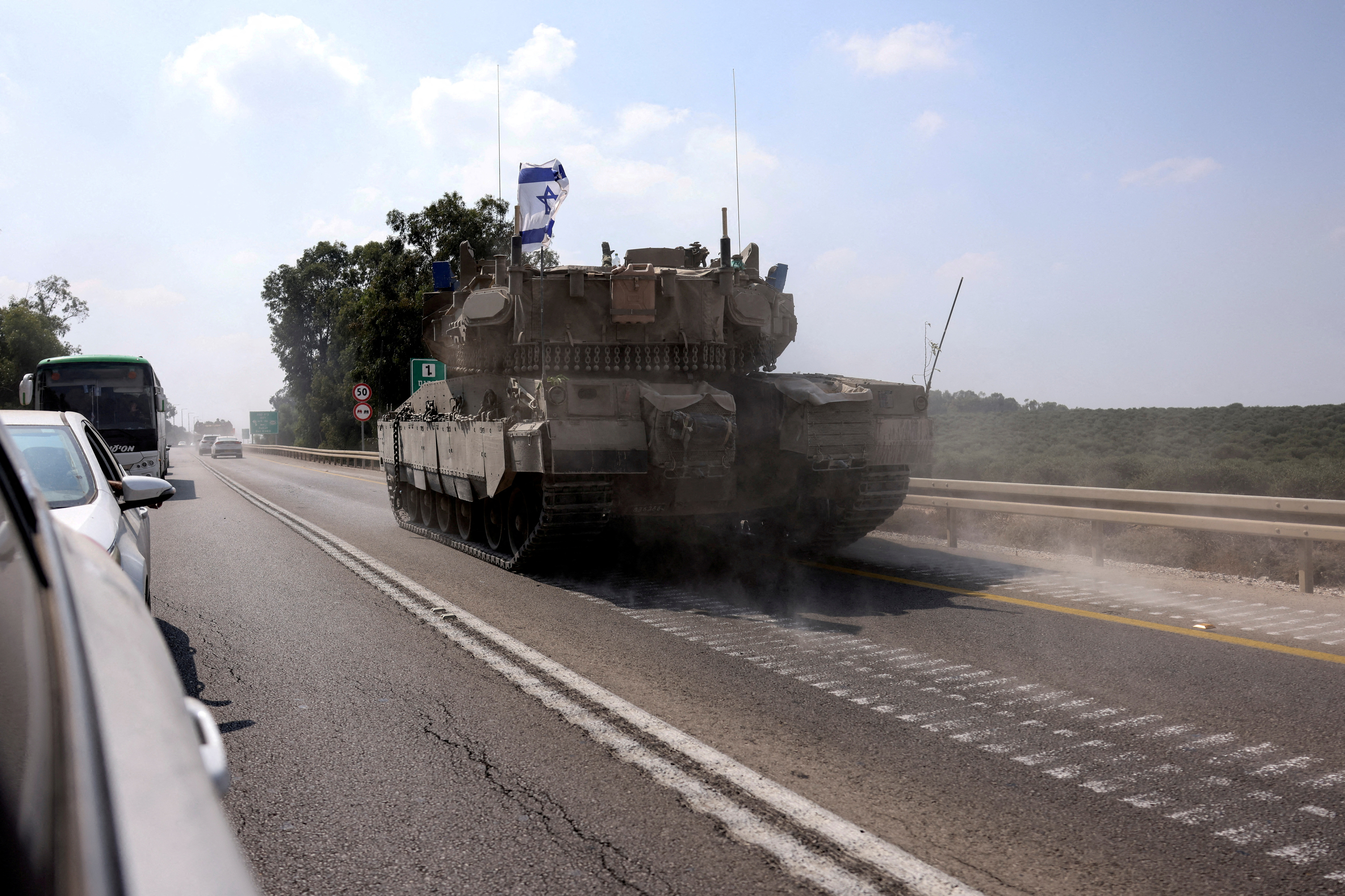 An Israeli tank drives on a road following a mass infiltration by Hamas gunmen from the Gaza Strip, near Sderot