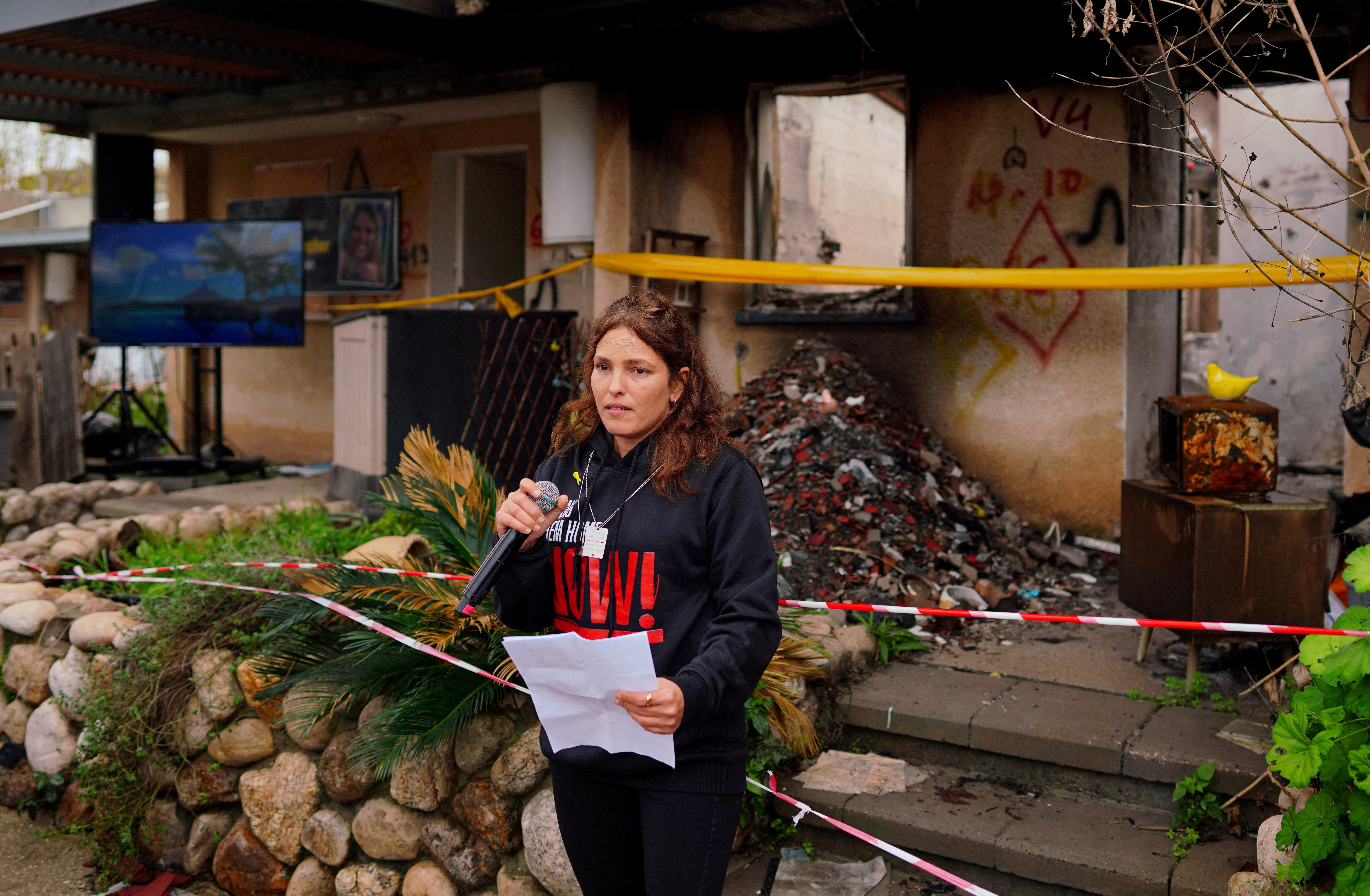 Released hostage Amit Soussana talks to the press in front of her destroyed home at the Kibbutz Kfar Aza