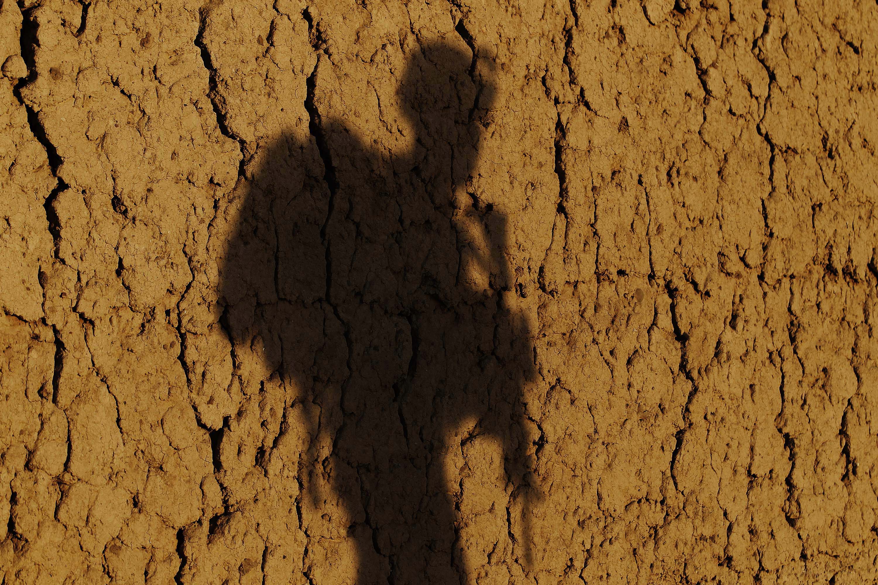 A U.S. Marine's shadow is cast on mud wall during a patrol in southern Afghanistan's Helmand province