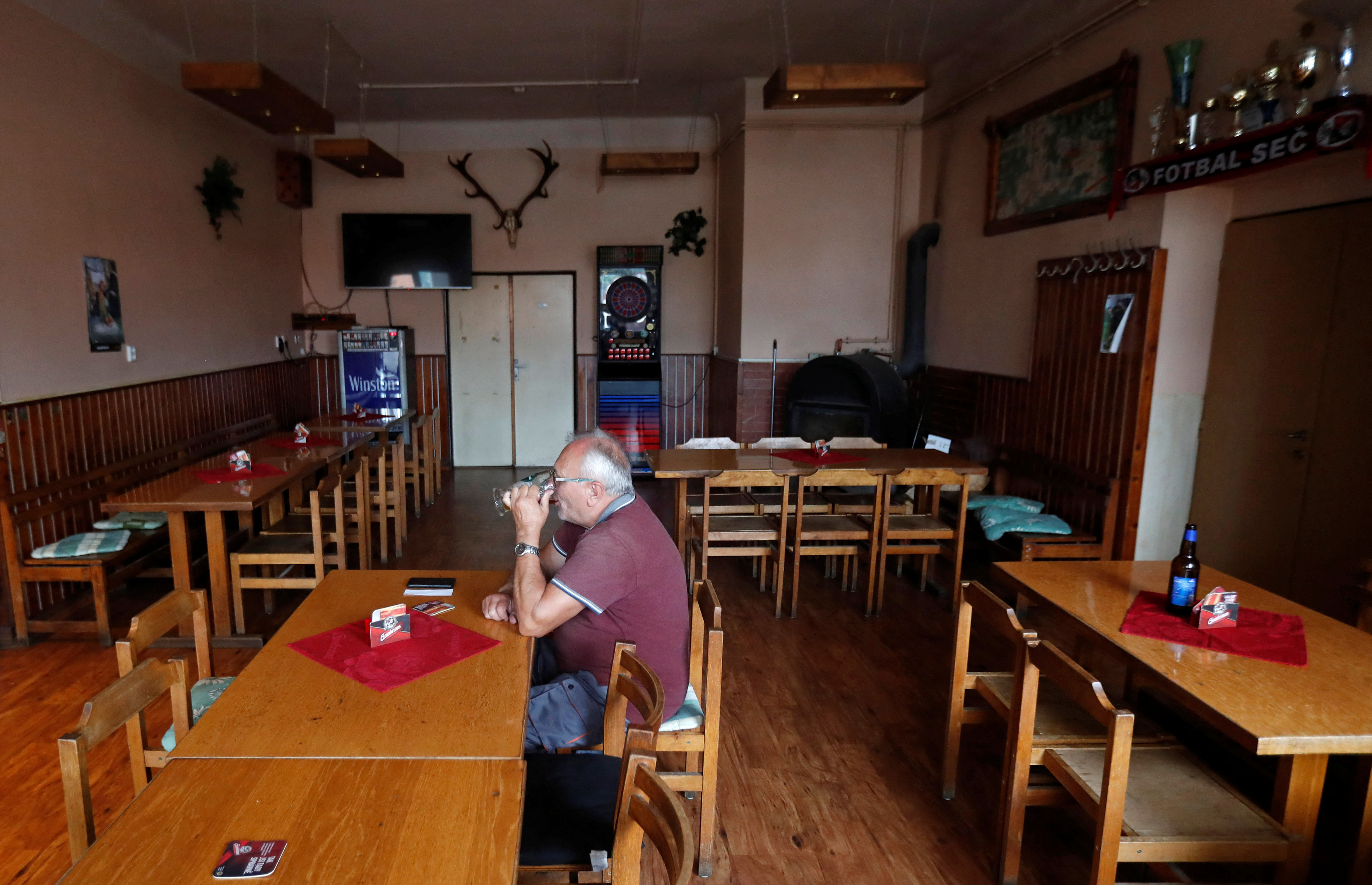 A customer drinks a beer inside a pub in the village of Sec