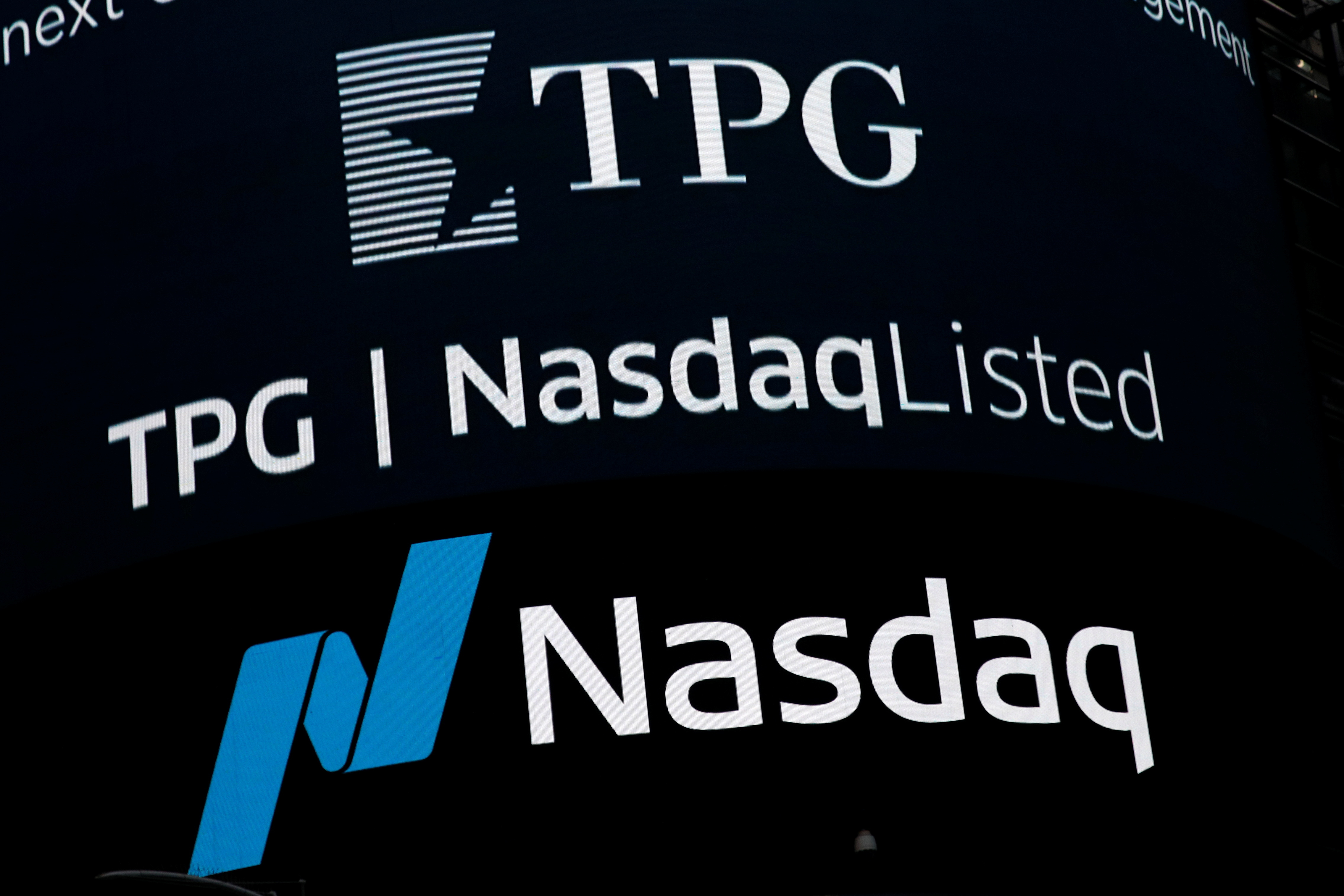 A screen announces the listing of Private-equity firm TPG, during the IPO at the Nasdaq Market site in Times Square in New York