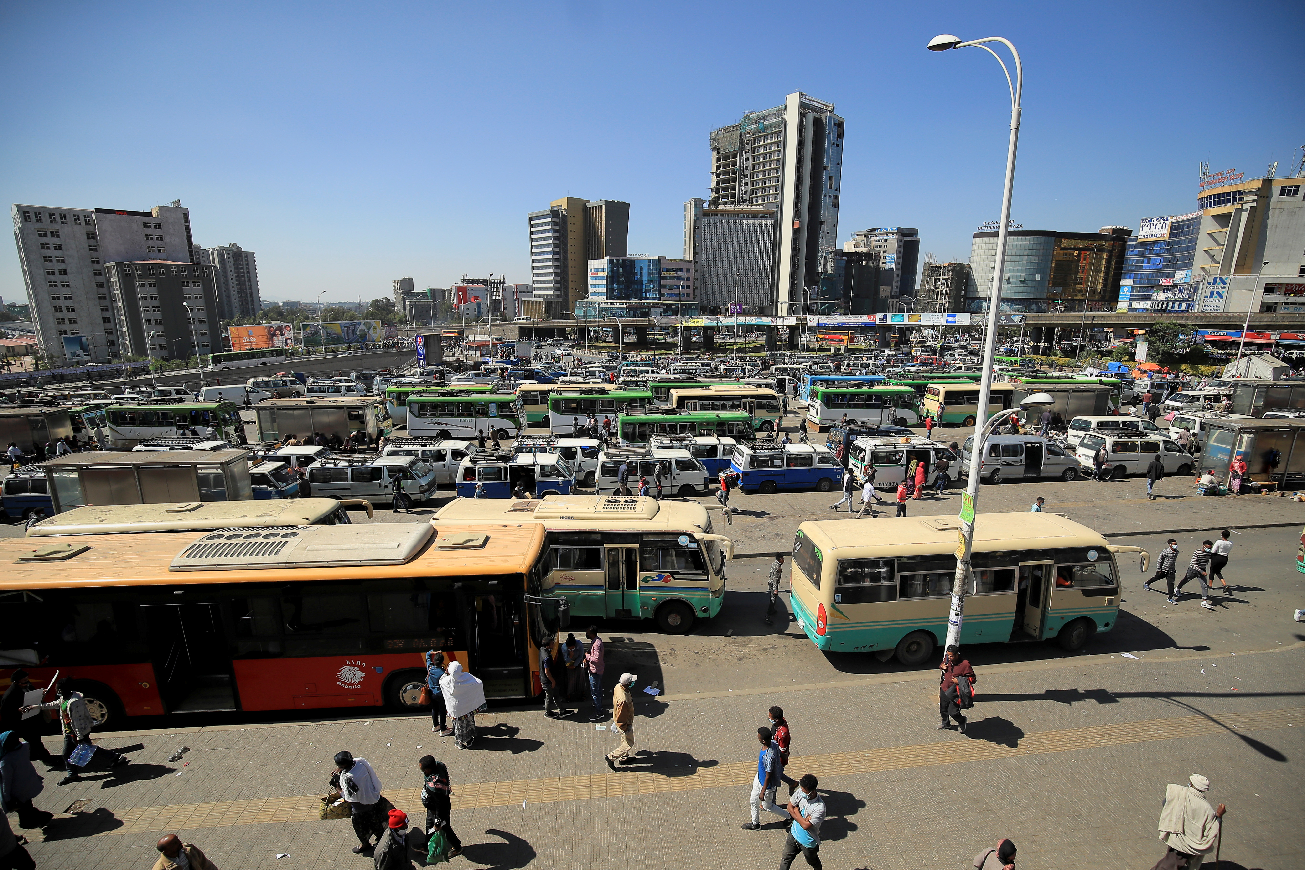 People walk through Megenagna neighbourhood bus station in Addis Ababa