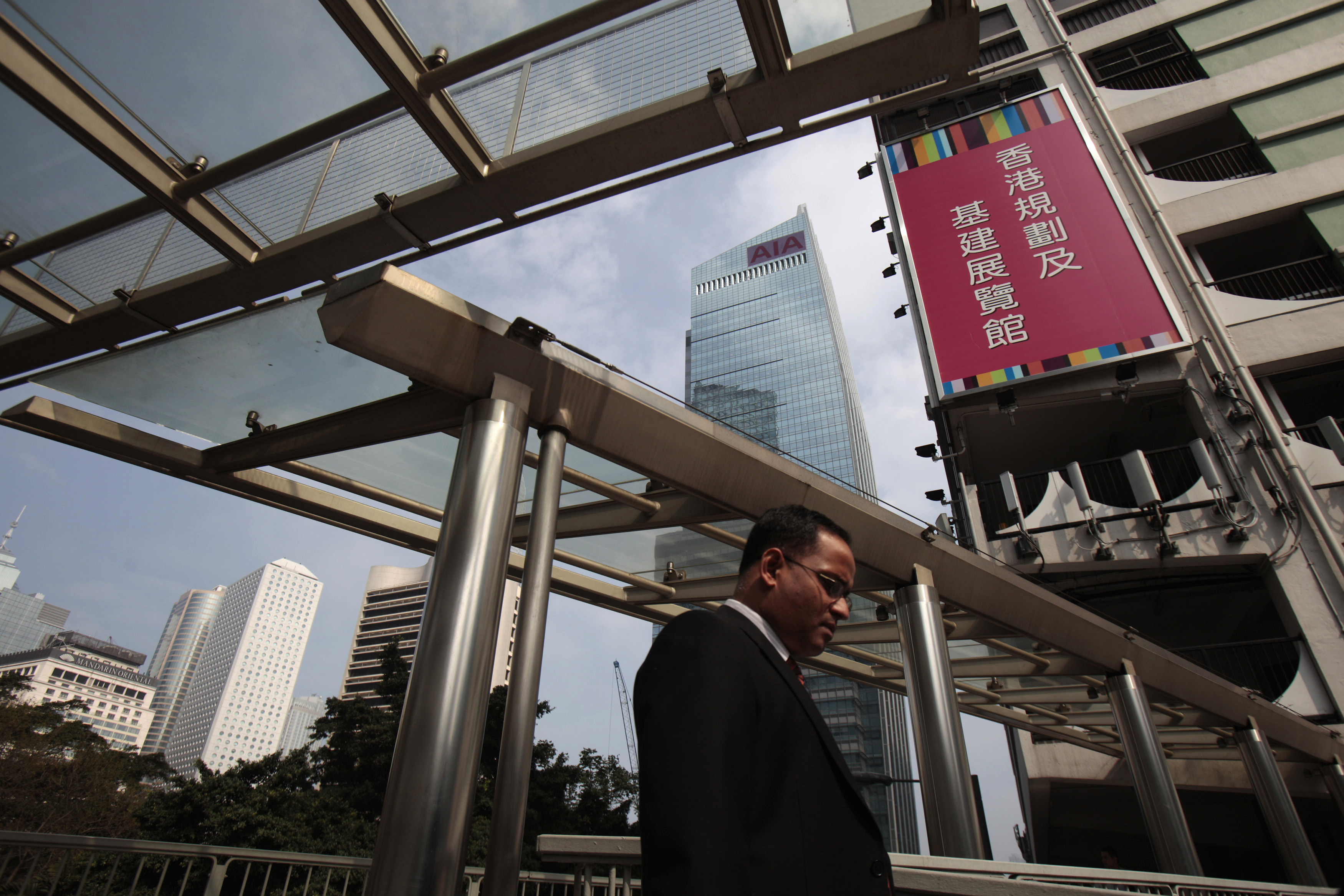 A man walks past the AIA Central in Hong Kong's financial district