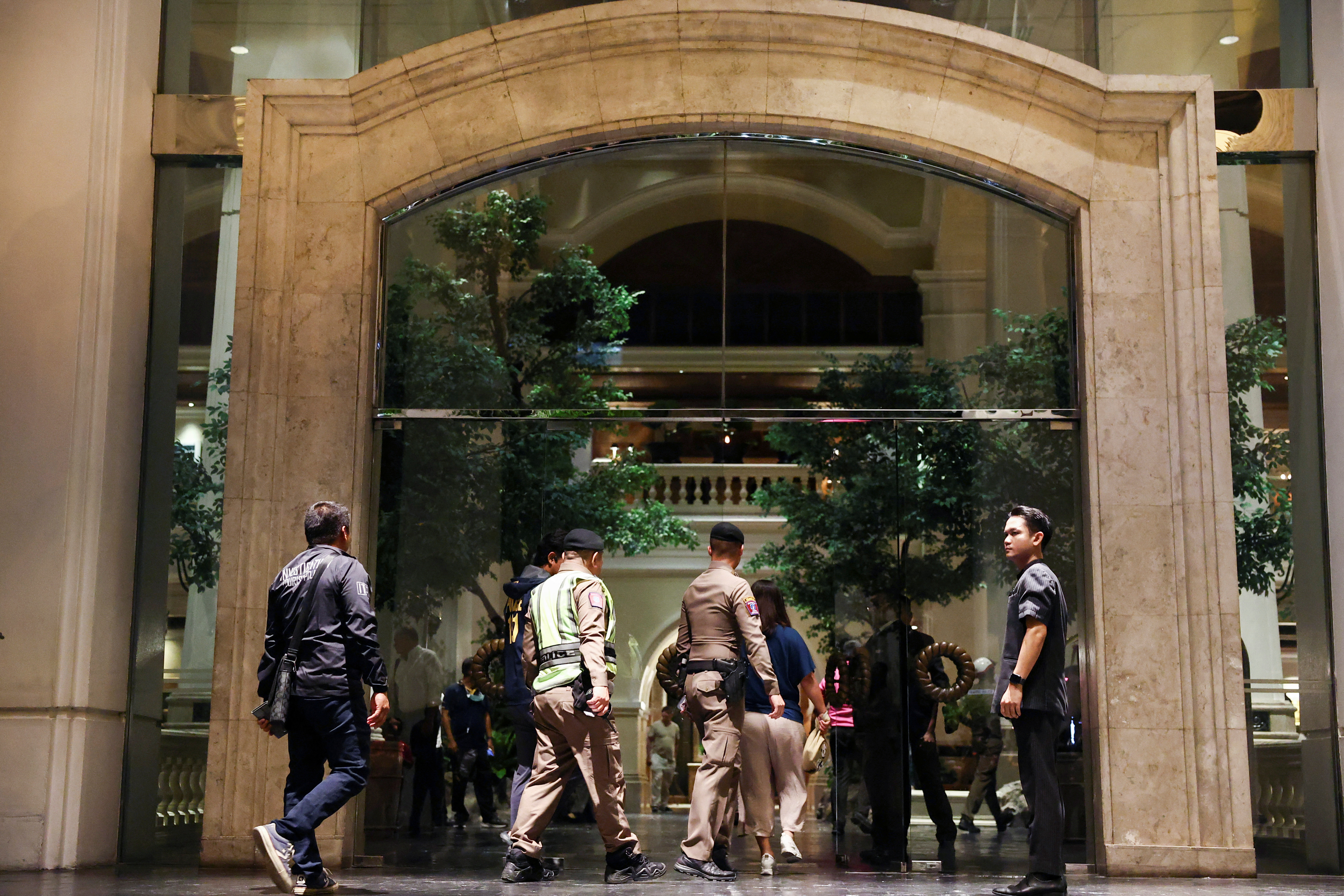 Policemen walk inside Grand Hyatt Erawan hotel, which believed that at least 6 people have been reported dead in Bangkok