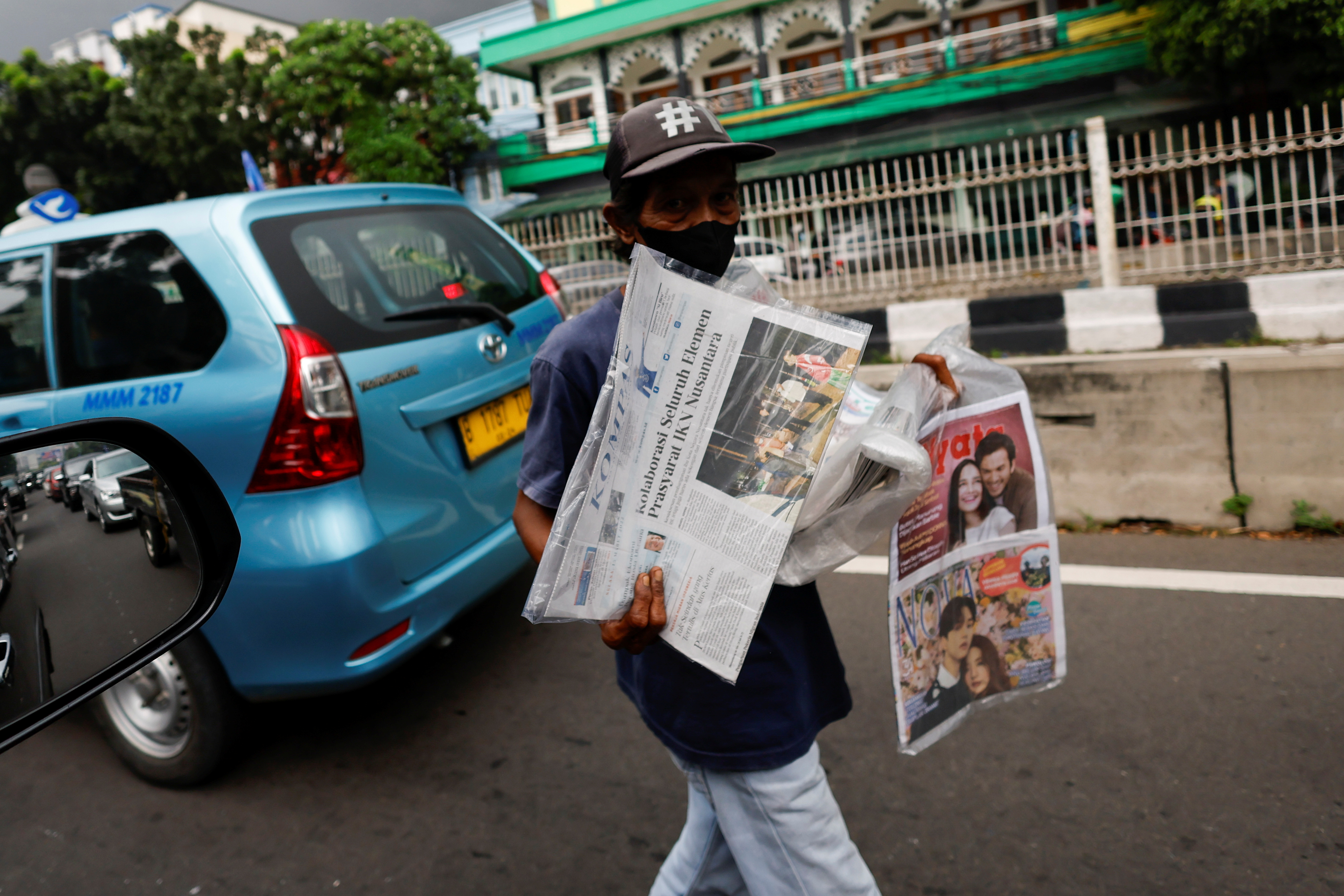 A street vendor sells papers with the news of Indonesian New Capital Nusantara (IKN) on its headline, during a traffic in Jakarta