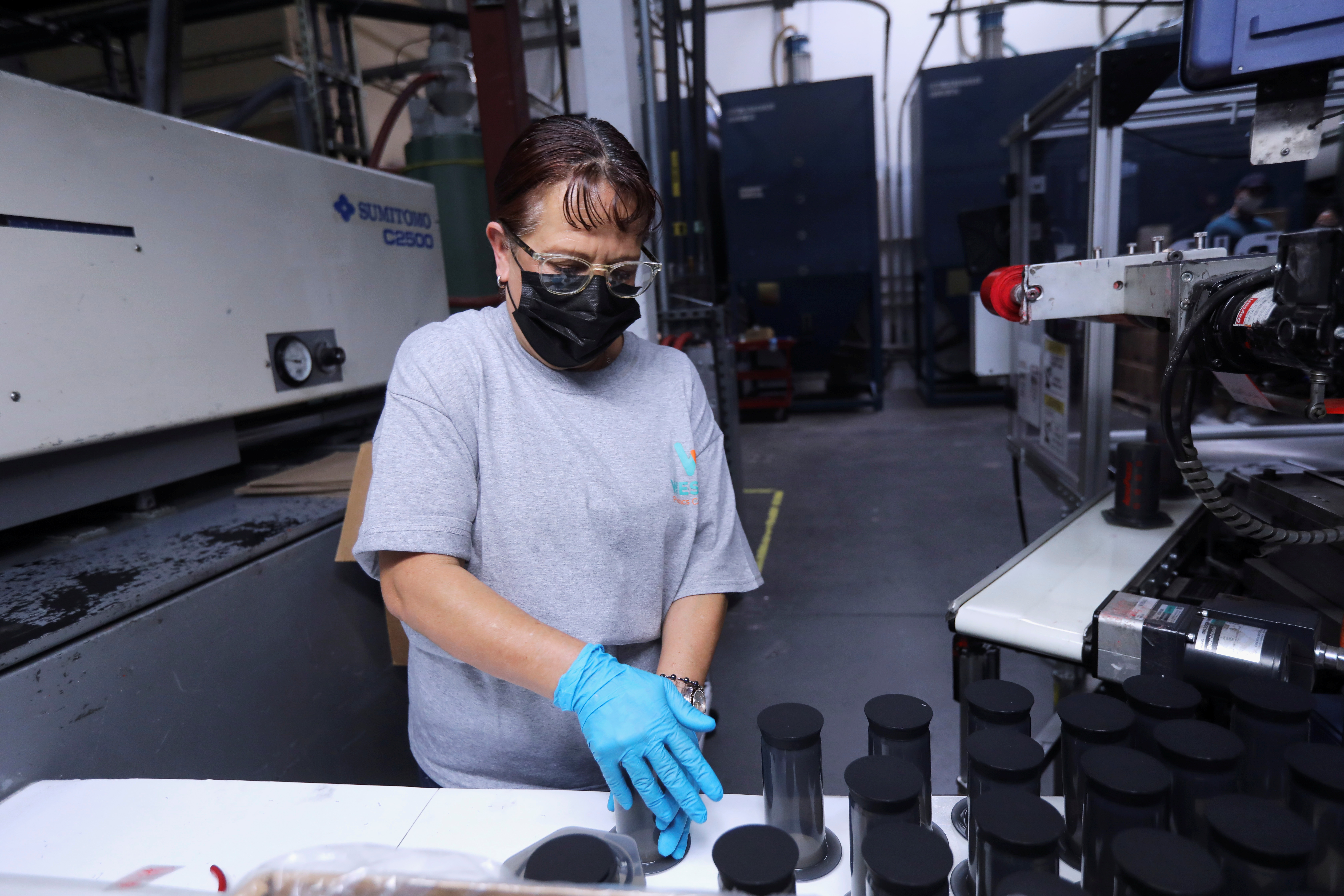 Worker Martha Escobar sorts products after they've been labeled with the help of a Rapid Robotics system at Westec Plastics Corp warehouse in Livermore, California
