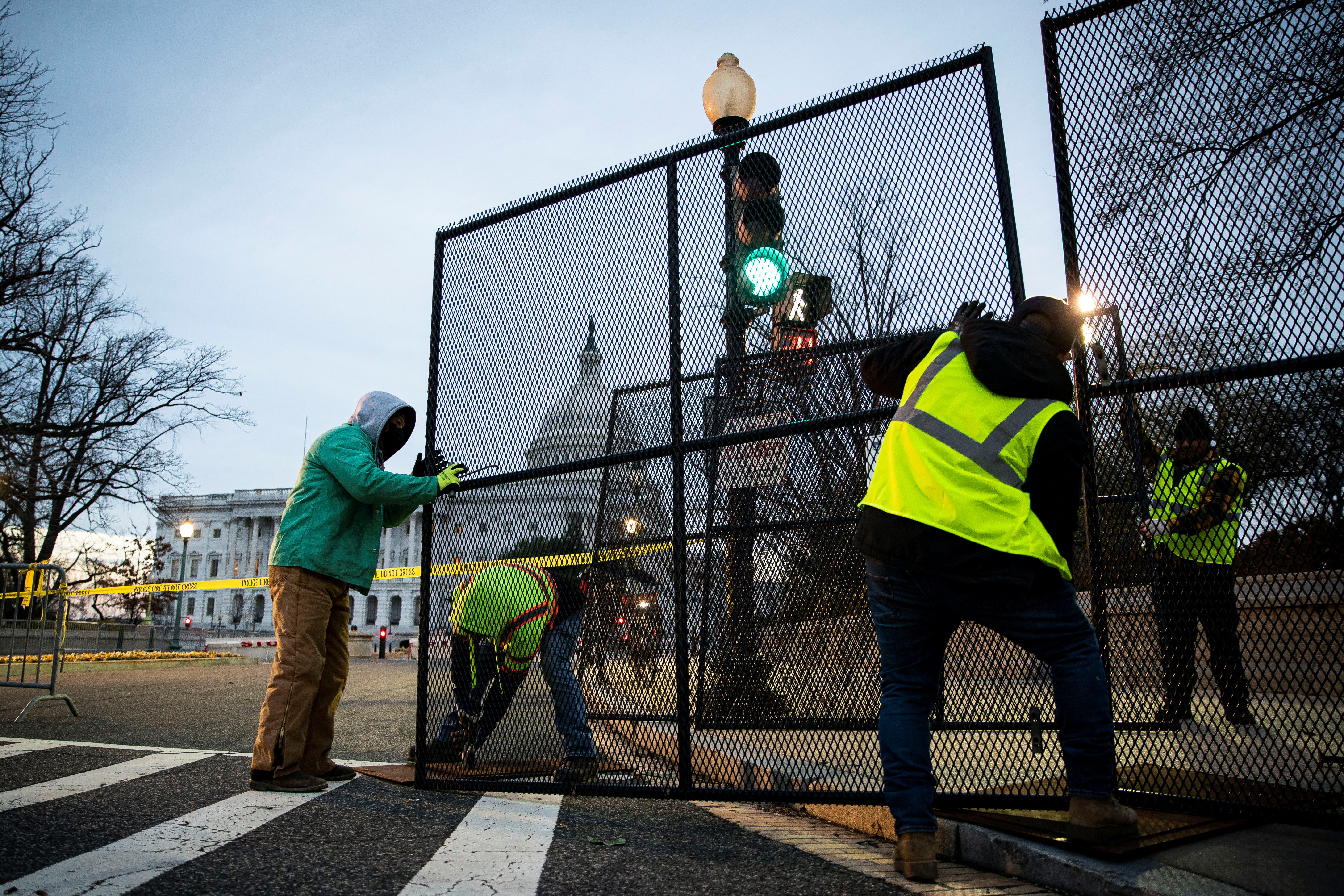 Workers install security fencing around the perimeter of the U.S. Capitol, ahead of the upcoming State of the Union with U.S. President Joe Biden