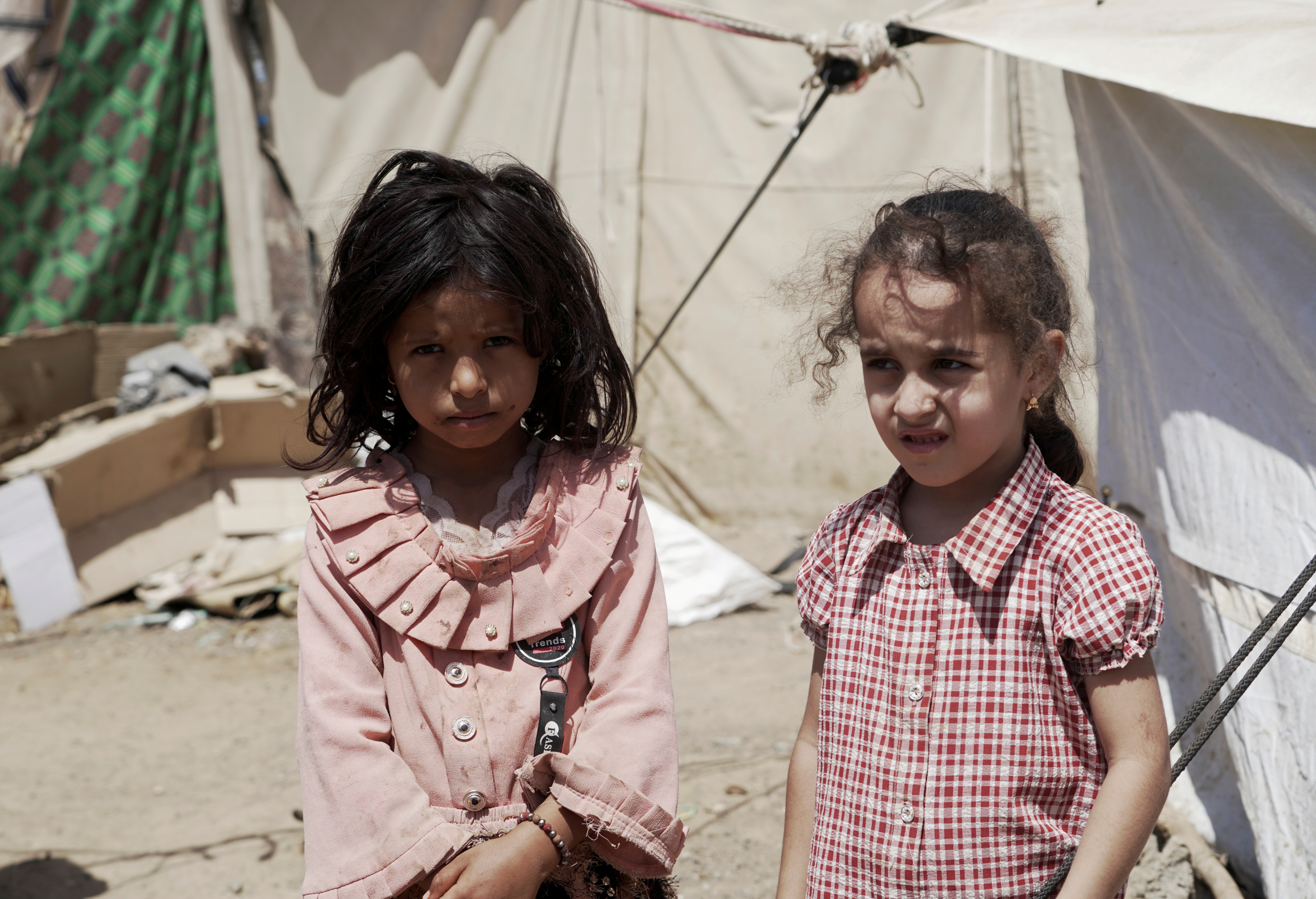 Girls stand outside a tent at a camp for internally displaced people (IDPs) on the outskirts of Marib city