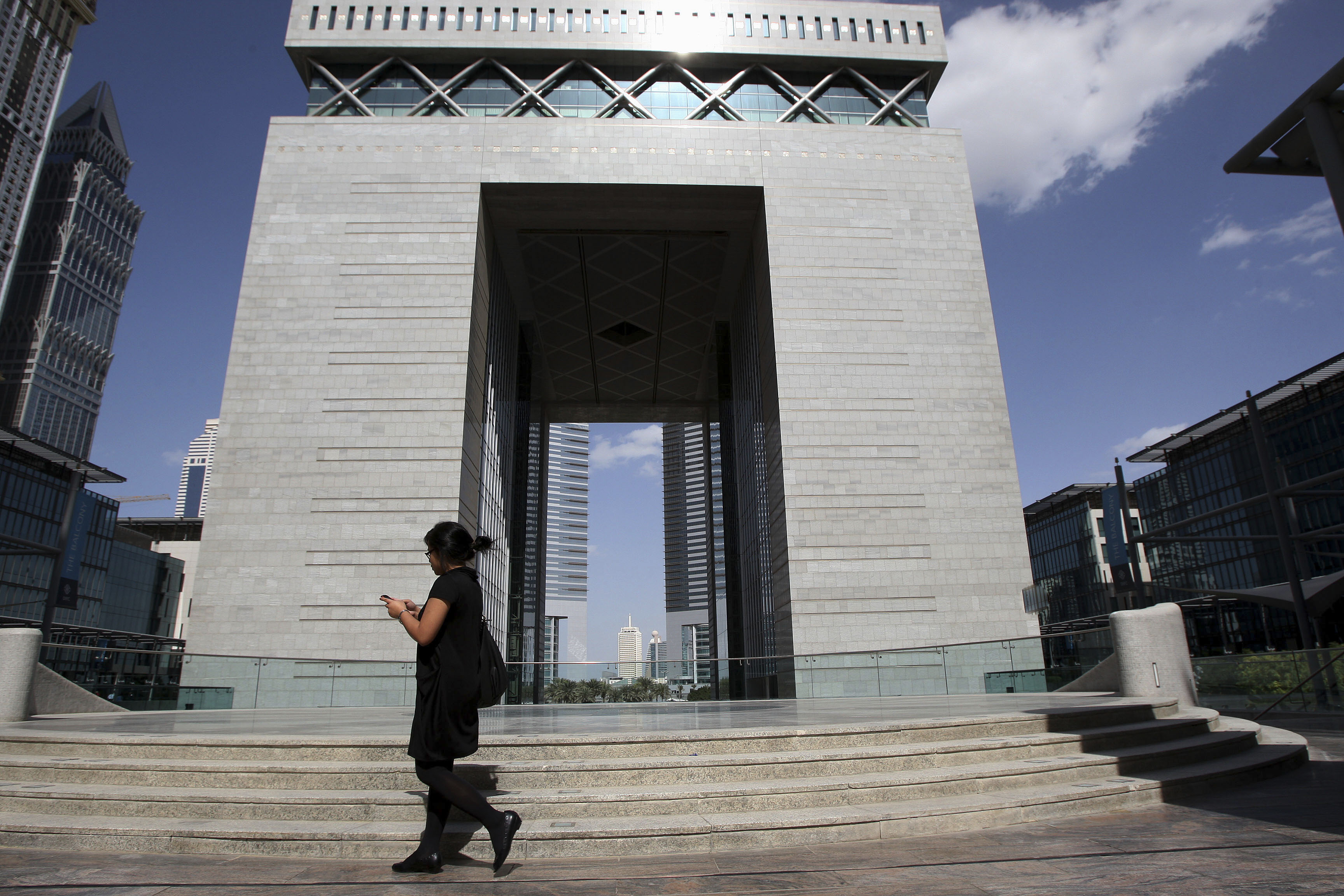A woman walks near The Gate building at the financial and business district Dubai International Financial Center in Dubai