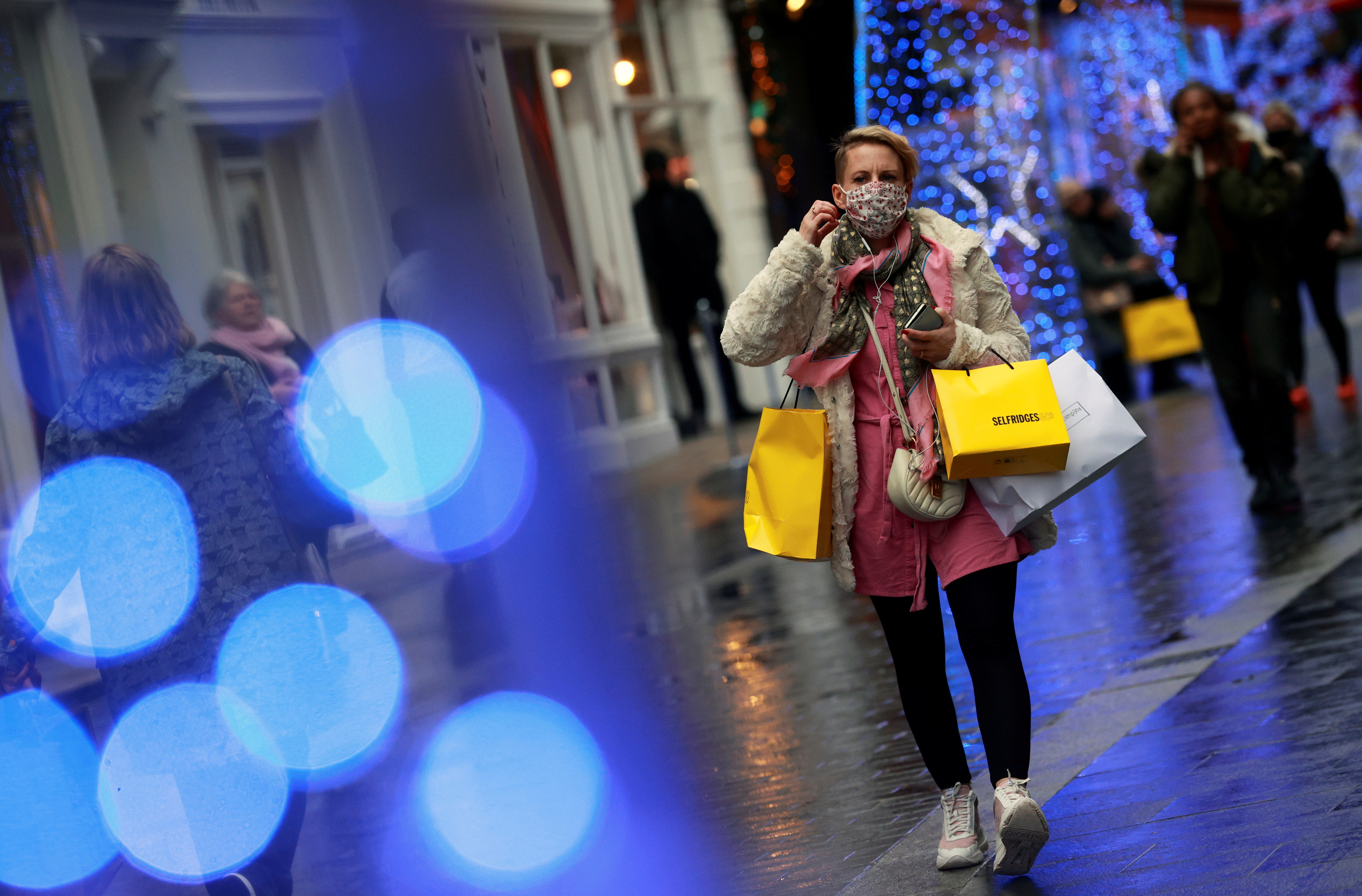 A shopper walks down the street in London, Britain December 18, 2020. REUTERS/Hannah Mckay/File Photo