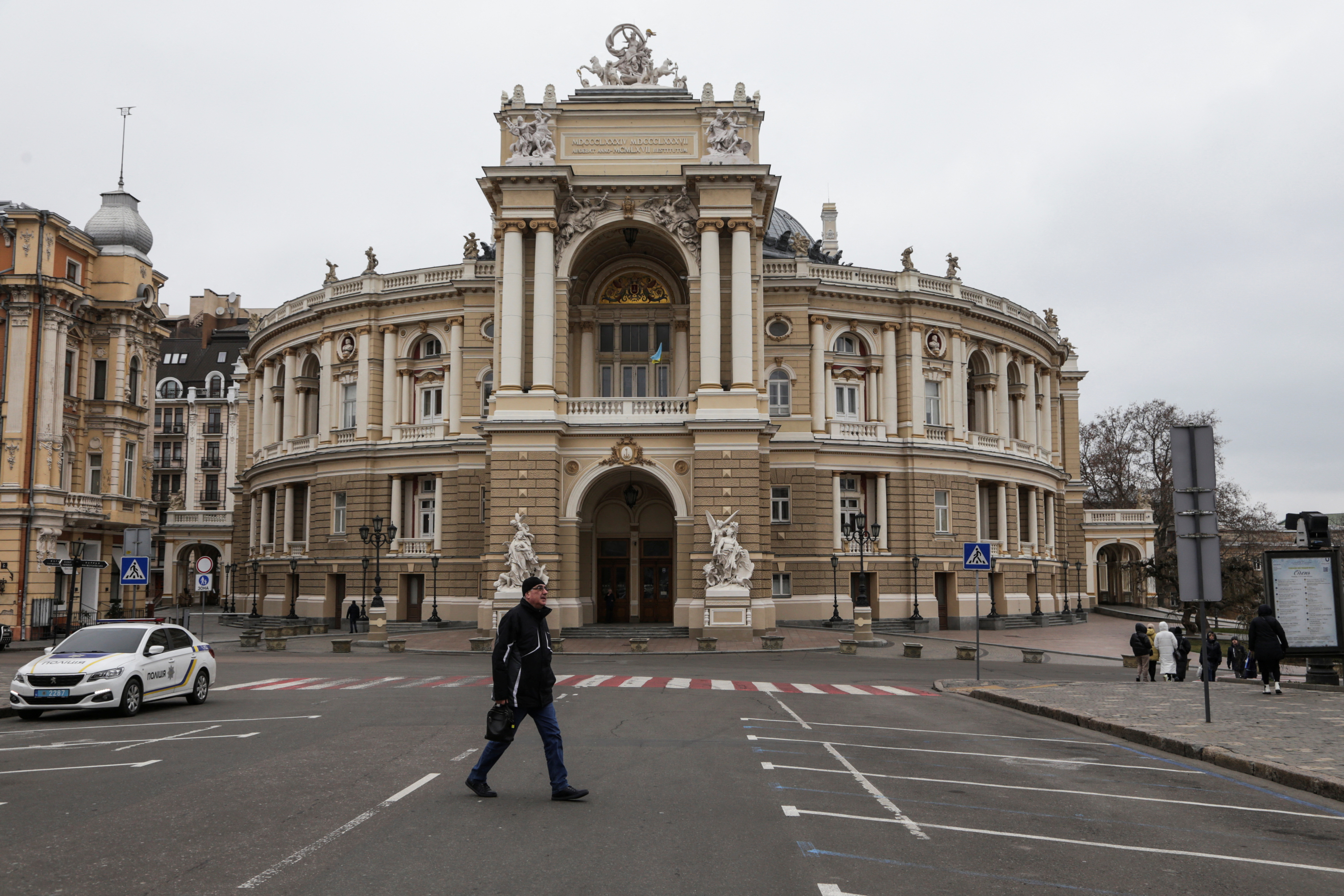 A man walks next to the Opera Theatre building in the city centre of Odesa