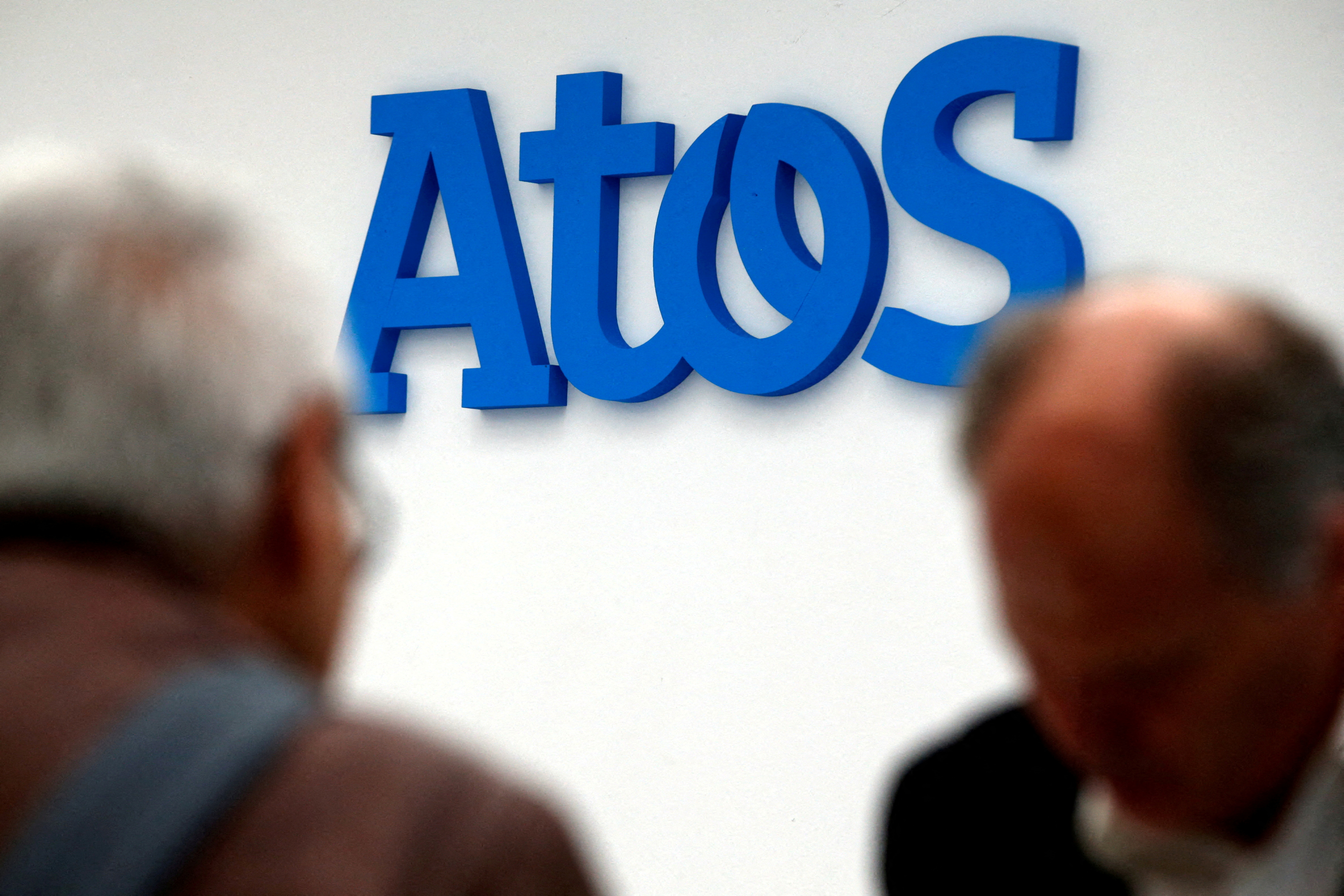 People walk in front of the Atos company's logo during a presentation of the new Bull sequana supercomputer in Paris