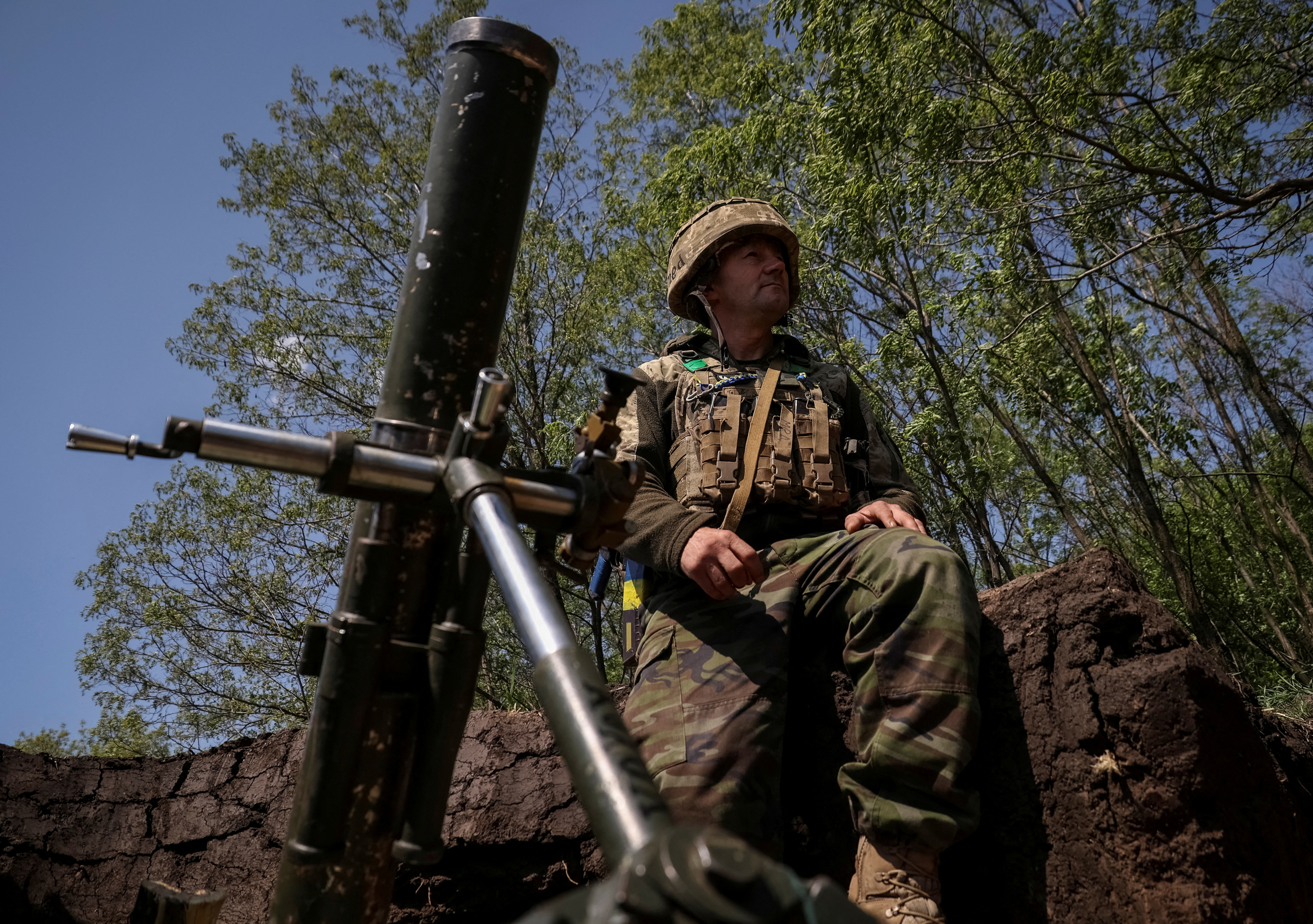 A Ukrainian service member prepares to fire a mortar at a front line near the city of Bakhmut