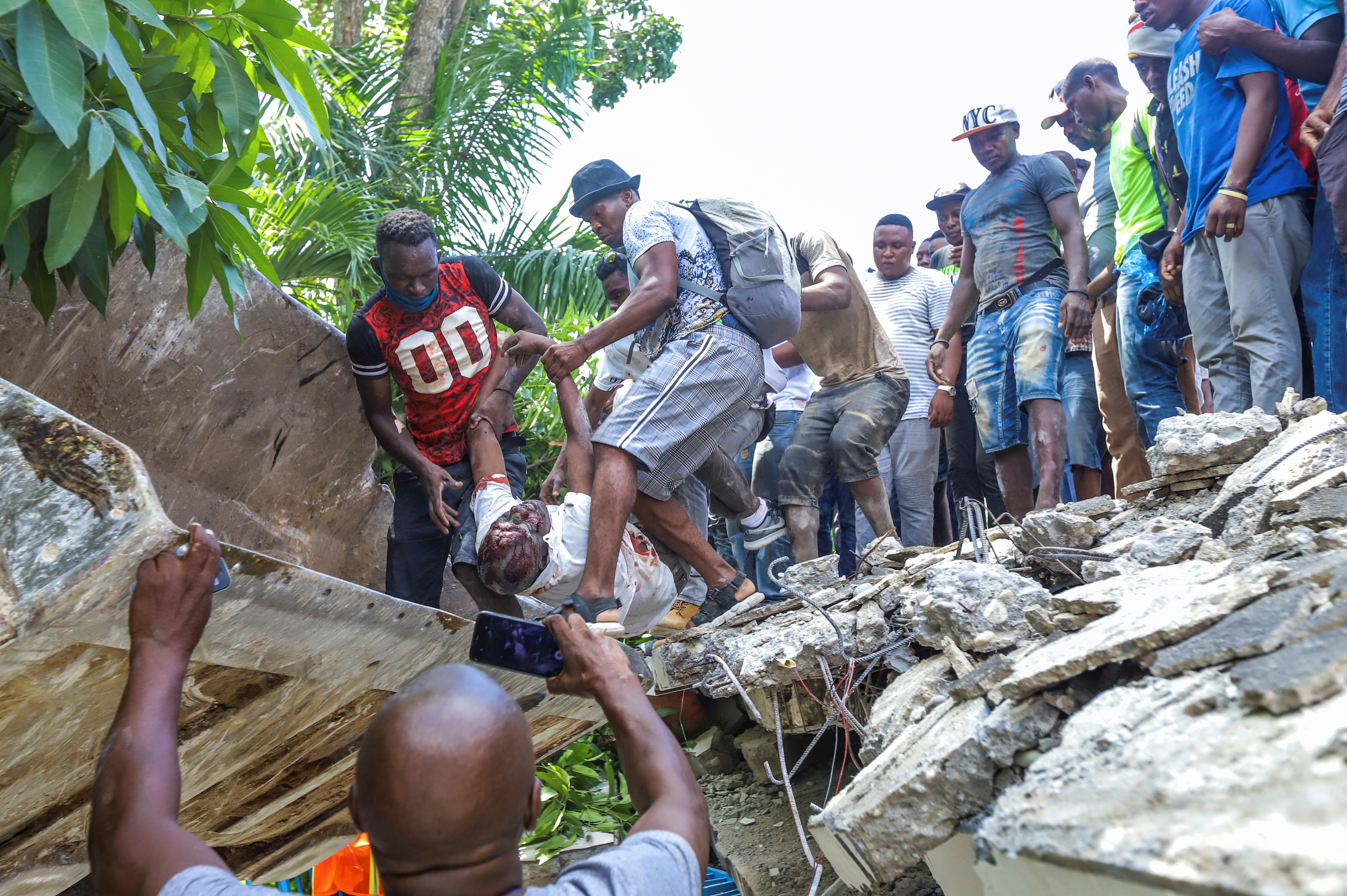 SENSITIVE MATERIAL. THIS IMAGE MAY OFFEND OR DISTURB People recover the body of politician Jean Gabriel Fortune from the rubble of a hotel following a 7.2 magnitude earthquake in Les Cayes, Haiti August 14, 2021. REUTERS/Ralph Tedy Erol NO RESALES. NO ARCHIVES