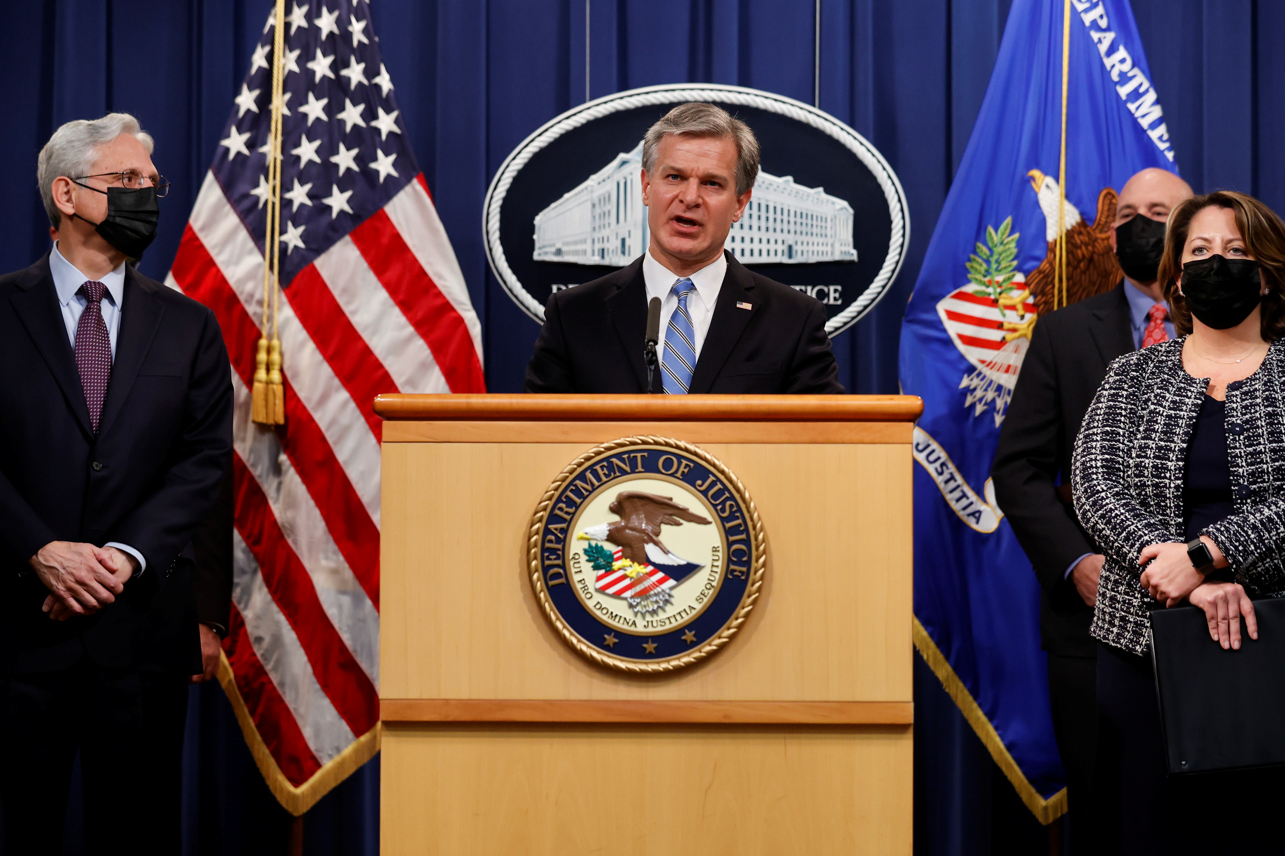 FBI Director Christopher Wray is flanked by U.S. Attorney General Merrick Garland and Deputy Attorney General Lisa Monaco as they discuss charges against a suspect from Ukraine and a Russian national over a July ransomware attack on an American company, during a news conference at the Justice Department in Washington, U.S., November 8, 2021. REUTERS/Jonathan Ernst