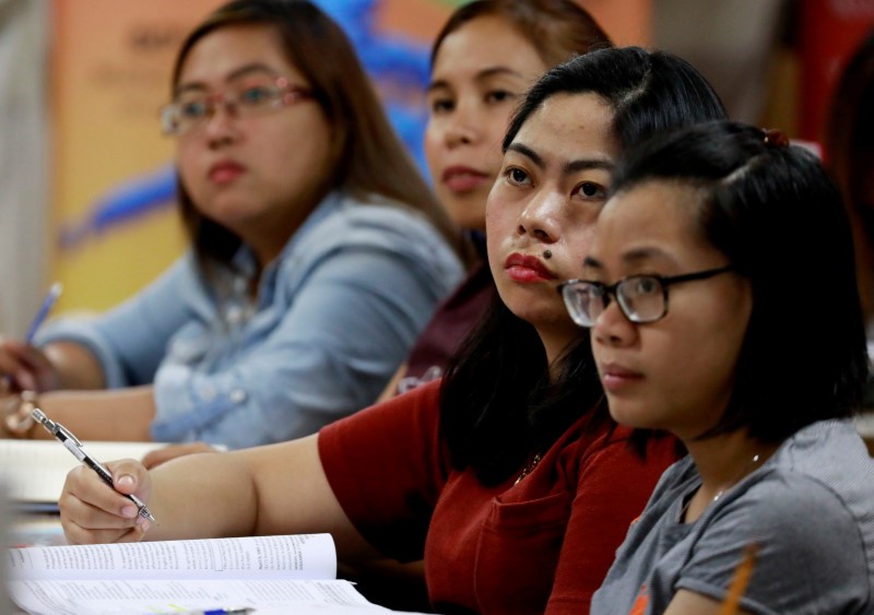 Filipino workers, including nurses applying to work in United Kingdom, attend a lecture at a review center