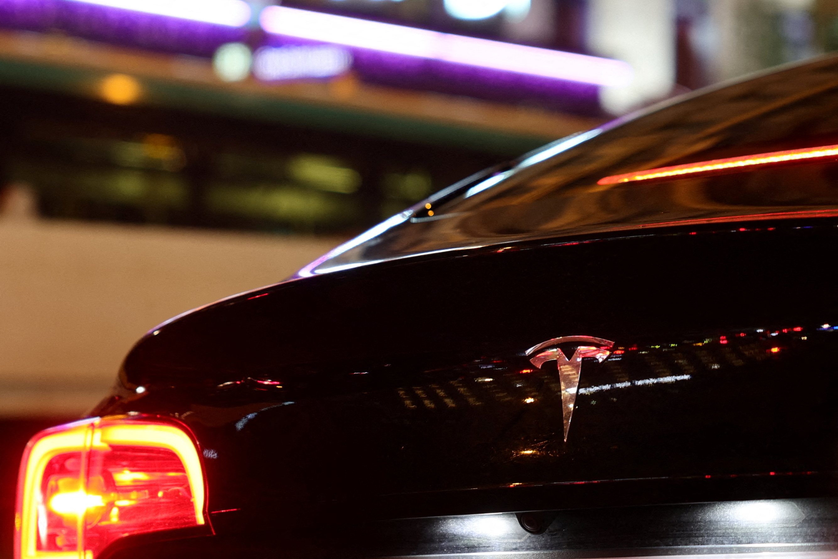 A Tesla logo is seen on a Parisian taxi car in Paris