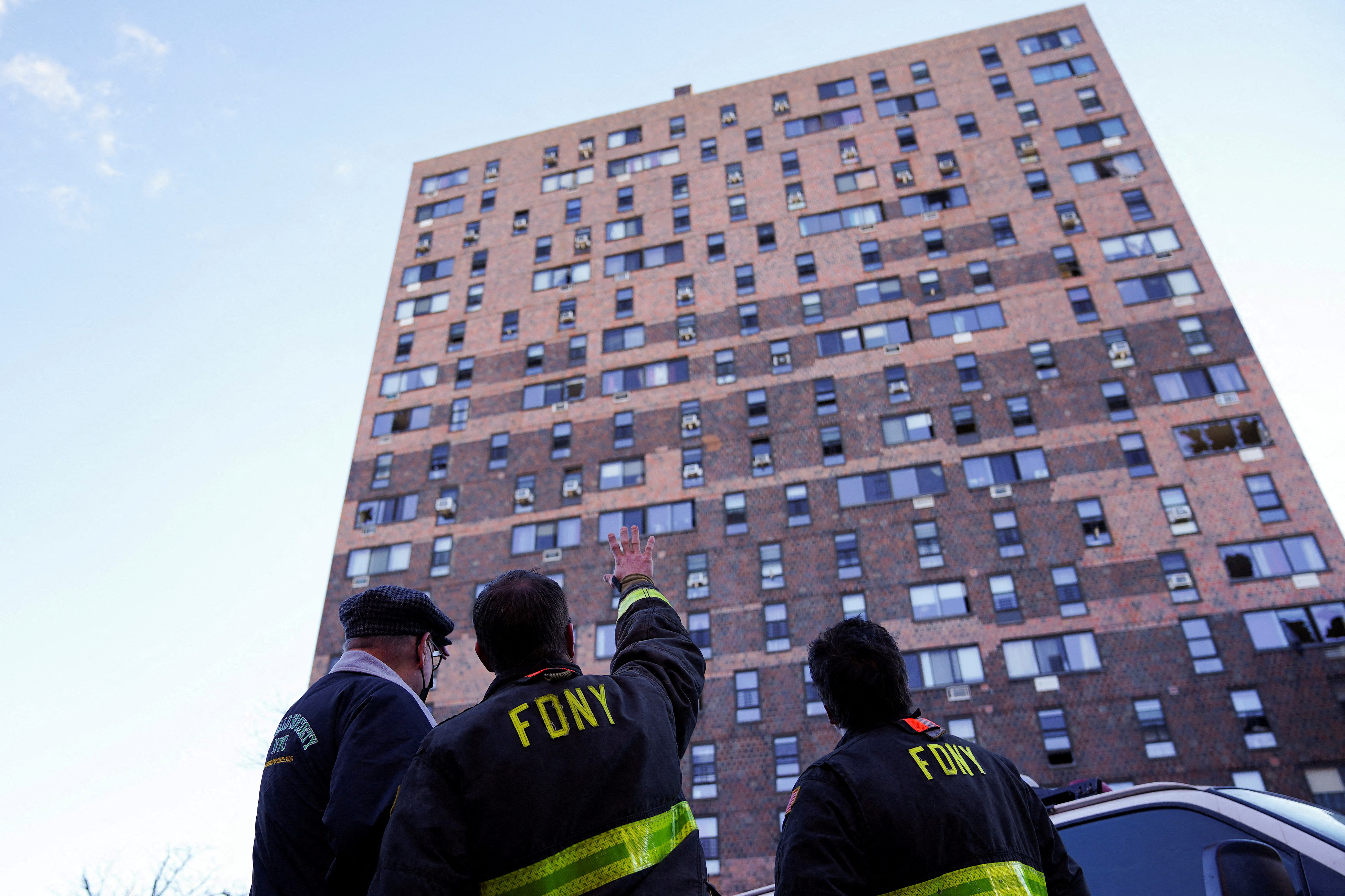Firemen stand at the scene of a fire at an apartment building in New York City