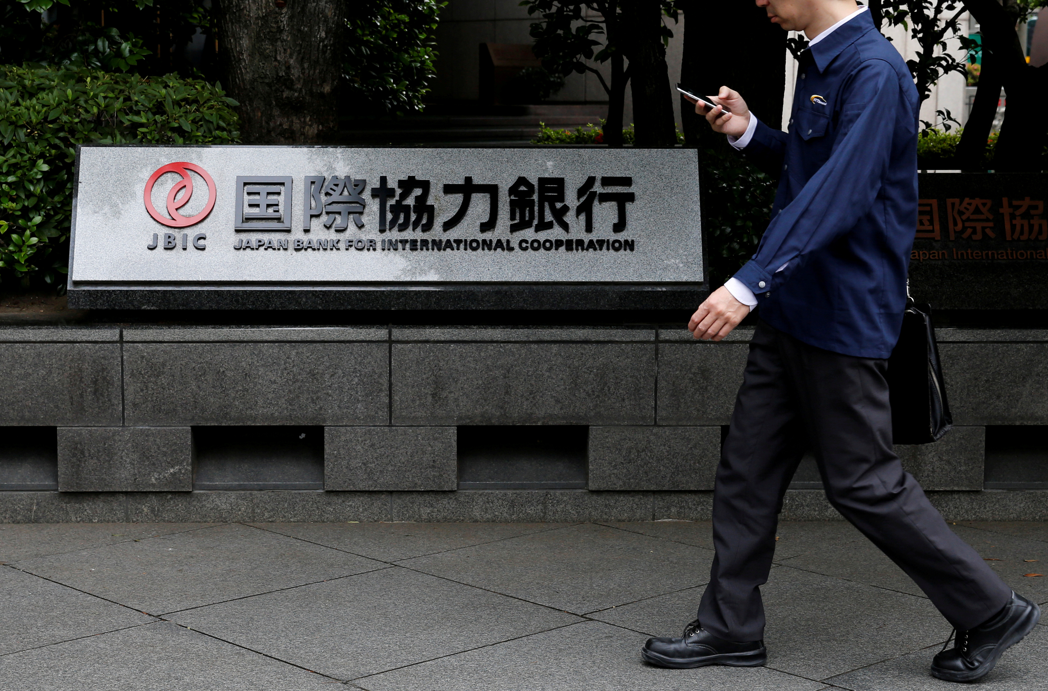 Man walks past a sign of Japan Bank for International Cooperation (JBIC) at it's headquarters in Tokyo