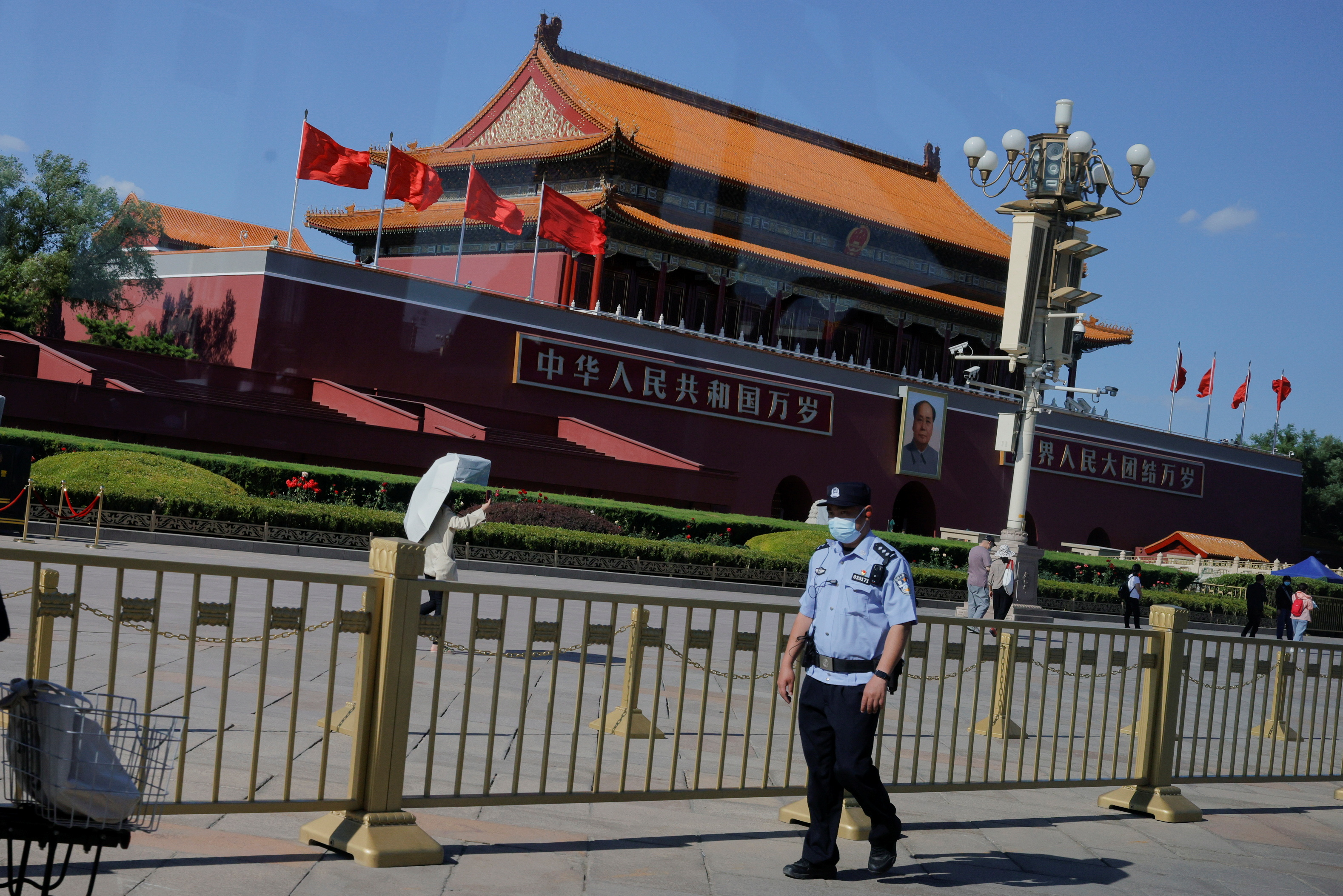 A police officer patrols in Tiananmen Square in front of a portrait of late Chinese chairman Mao Zedong in Beijing