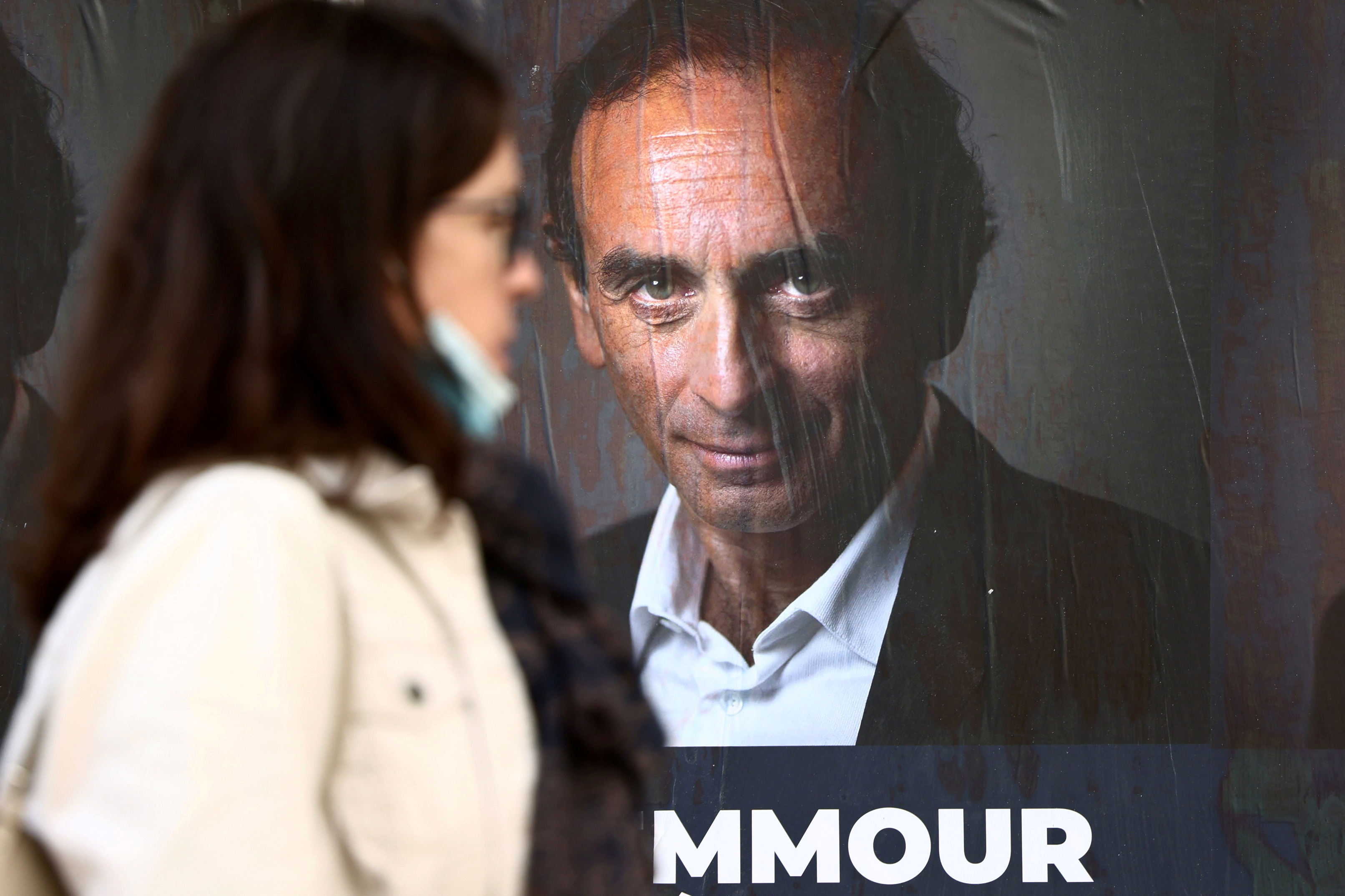 A woman walks past posters in support of French right-wing extremist commentator Eric Zemmour, likely candidate for the French presidential election next April, posted on a wall in Paris, France, 13 October 2021. Photo taken 13 October 2021. REUTERS / Sarah Meyssonnier / Photo