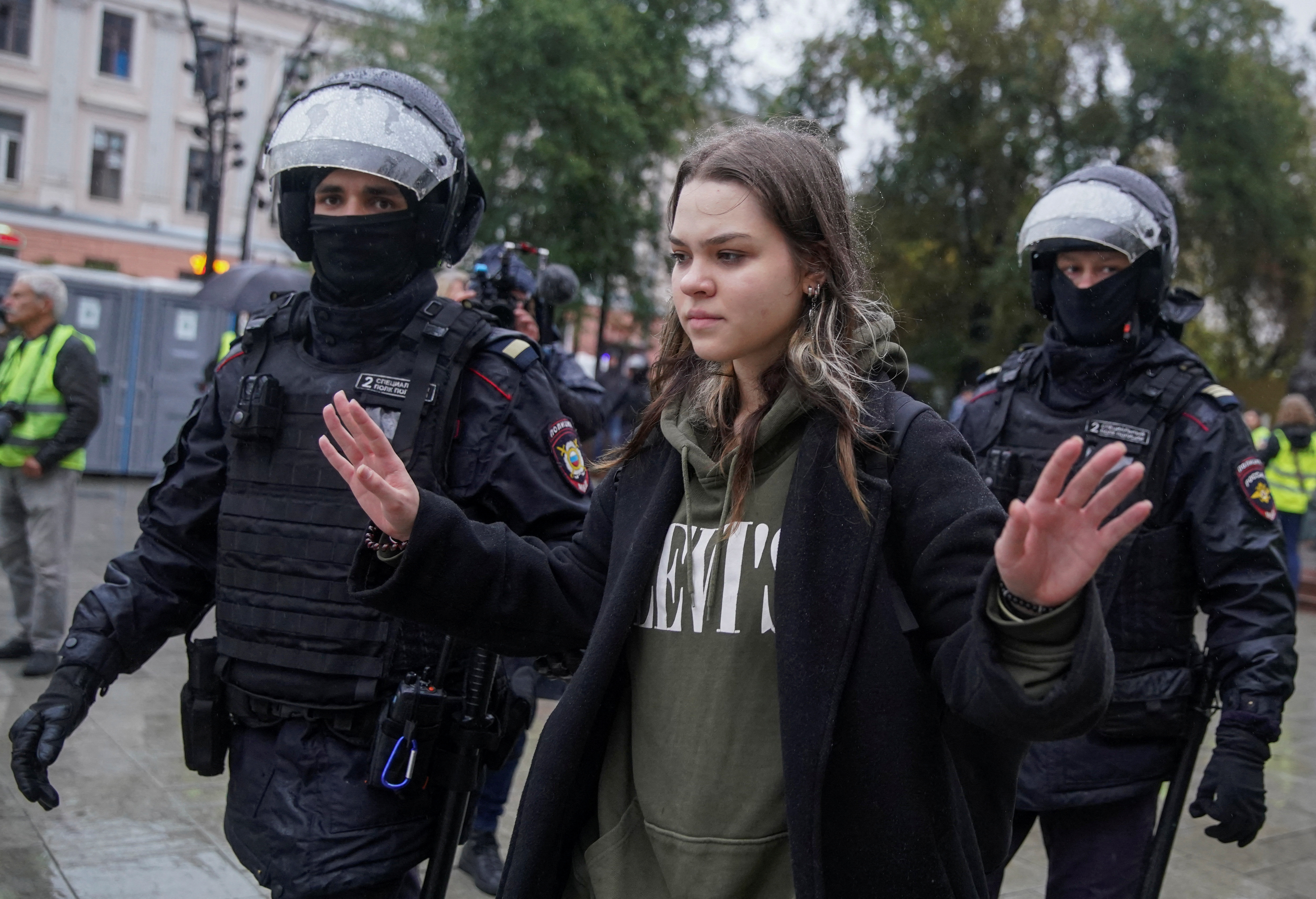 Russian police officers lead away a person during a rally in Moscow