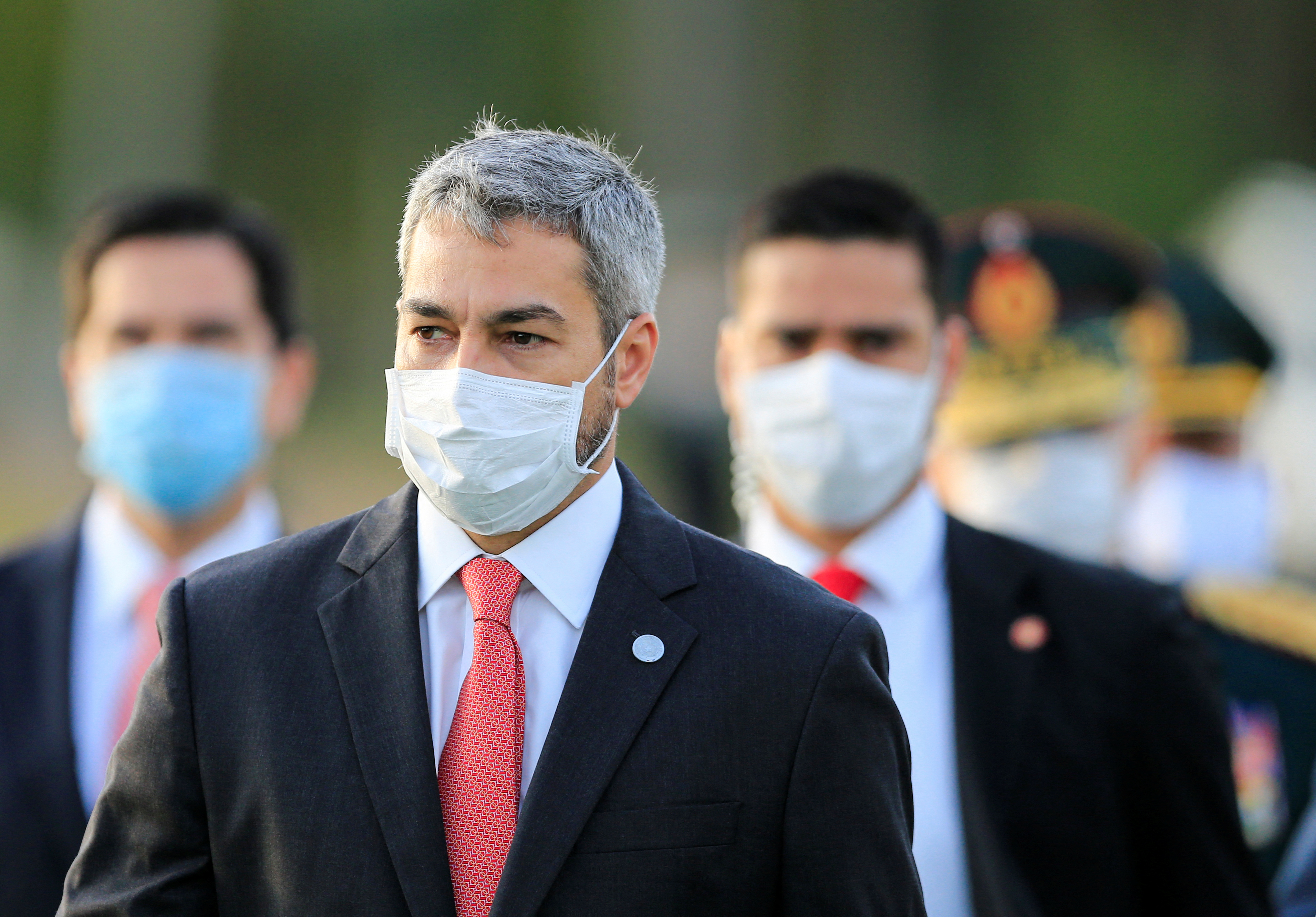 President Mario Abdo Benitez wears a face mask as he arrives for a ceremony in tribute to veterans of the 1932-1935 Chaco War, at the La Victoria barracks in San Lorenzo
