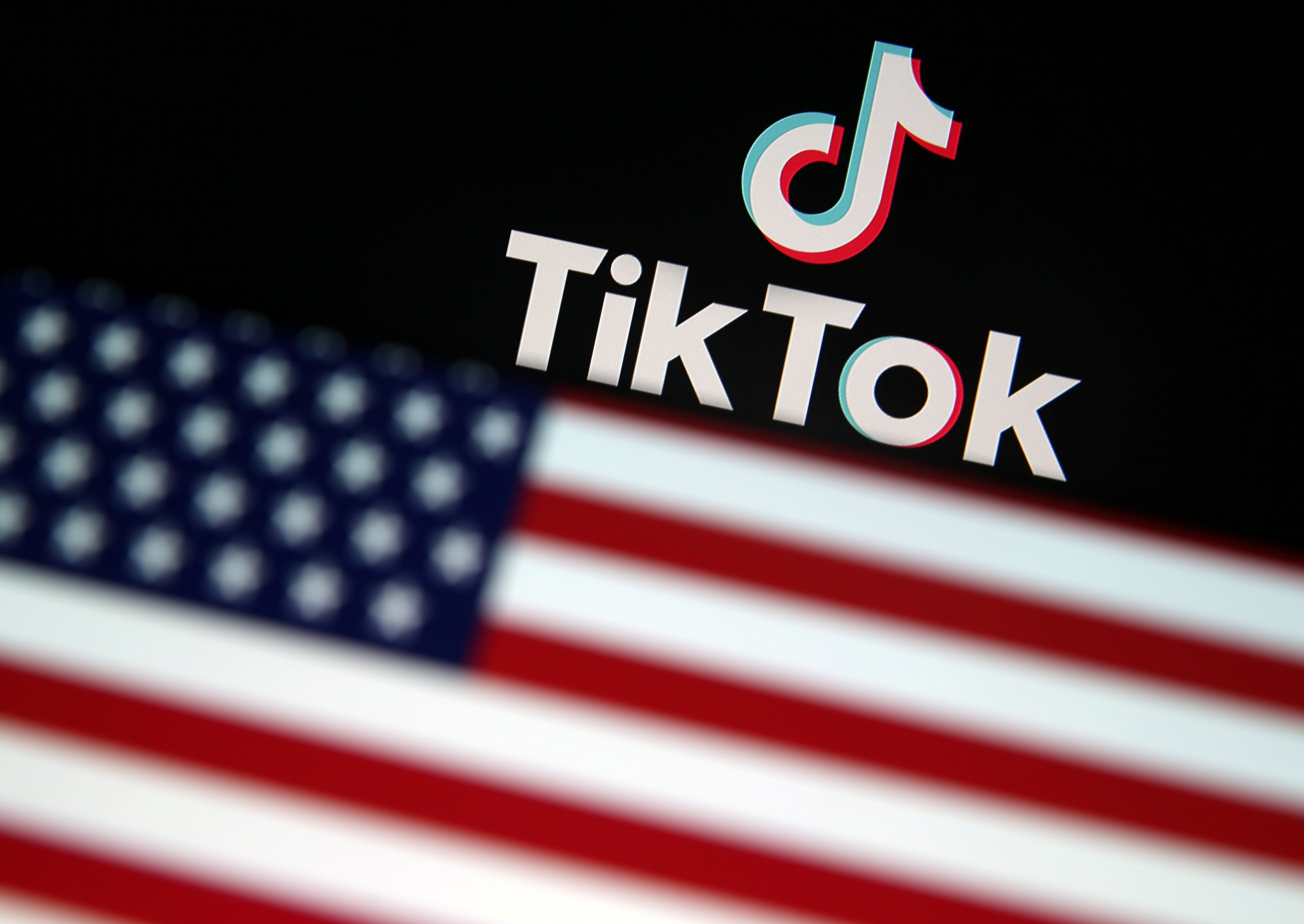 USA flag is displayed in front of Tik Tok logo in this illustration picture