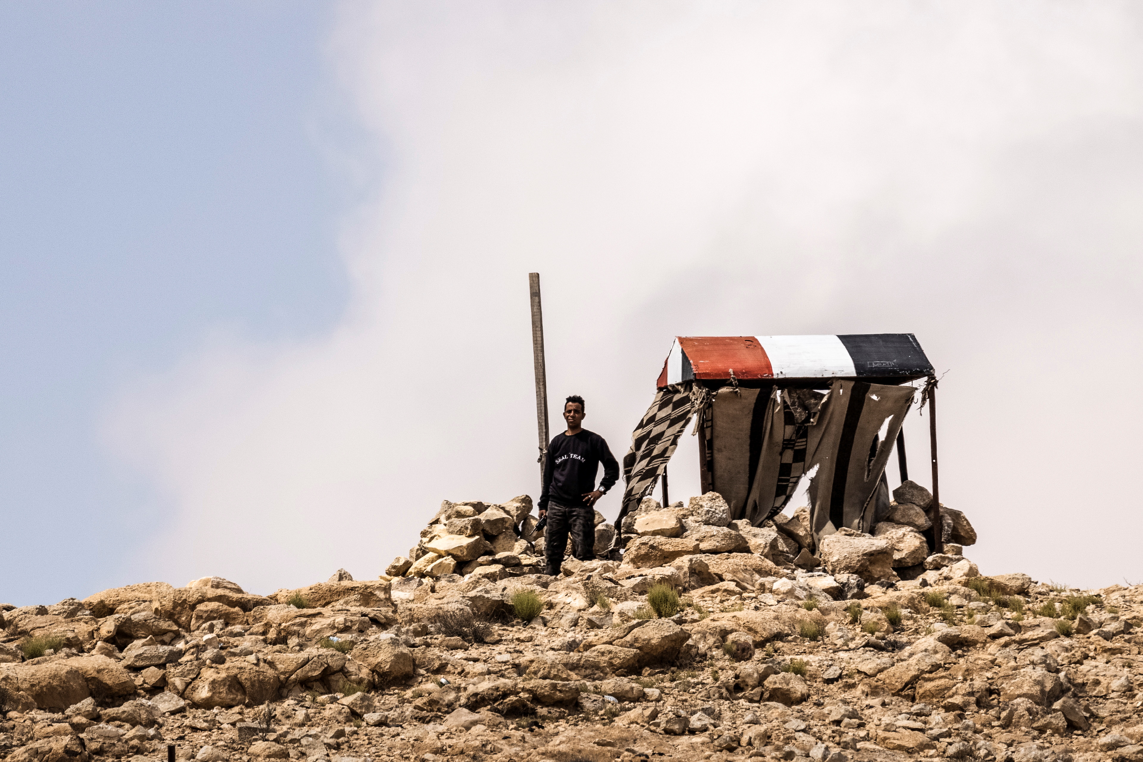 An Egyptian man looks on by an Egyptian military outpost at the Israel-Egypt border as seen from southern Israel
