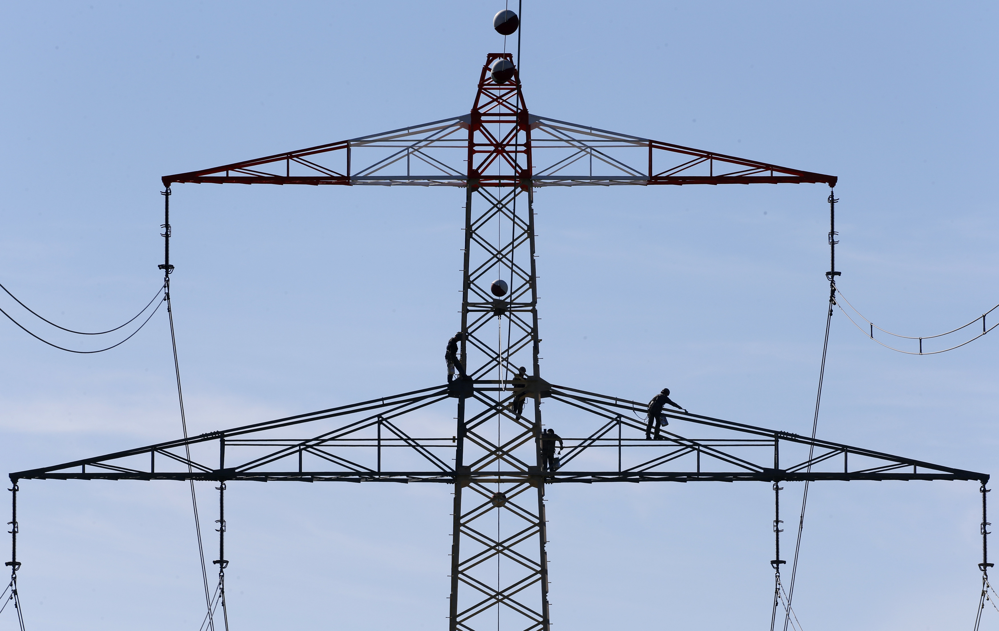 Workers renovate an electricity pylon near Gilching south of Munich