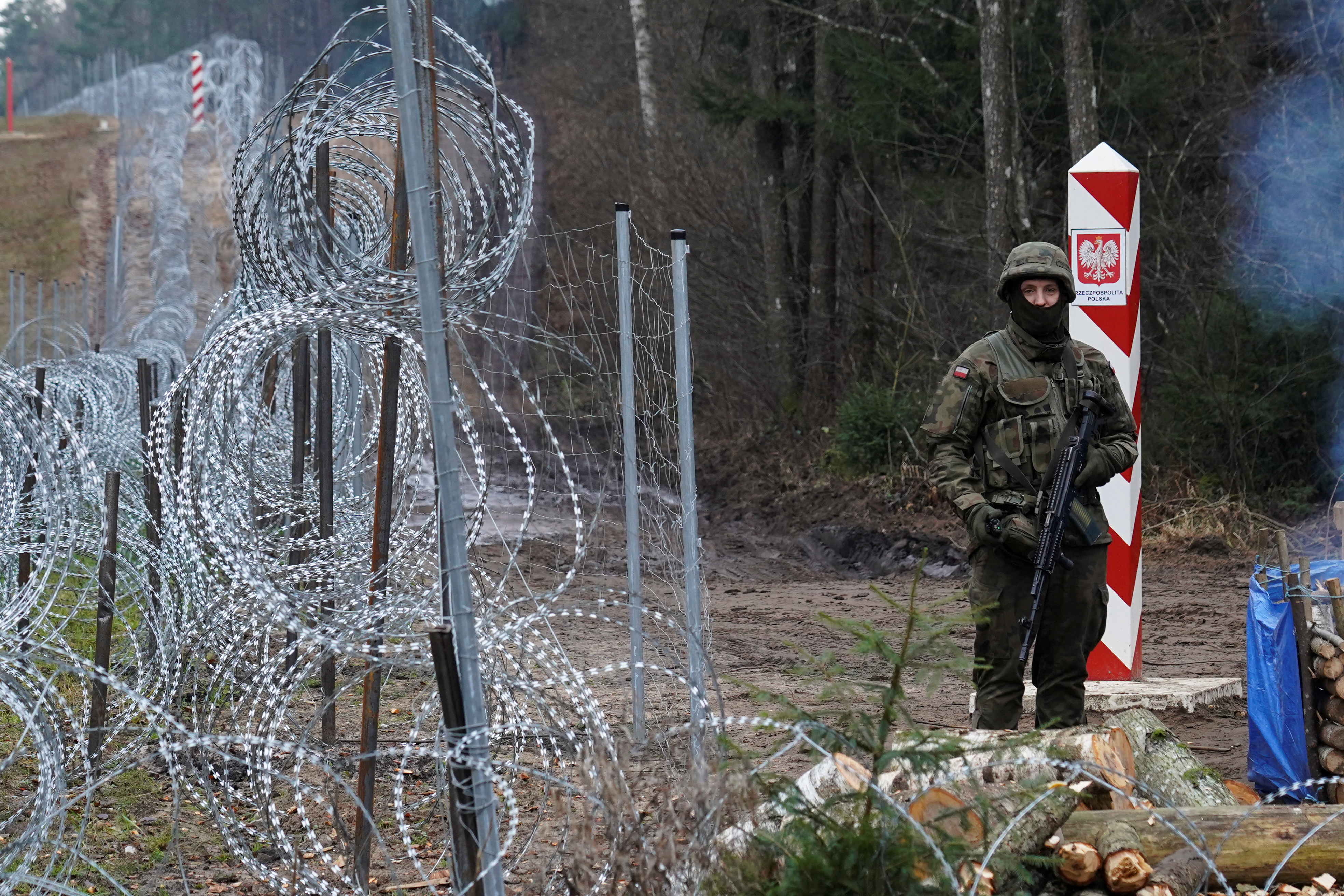 A Polish border guard stands guard near the Belarus border near Kapciamiestis